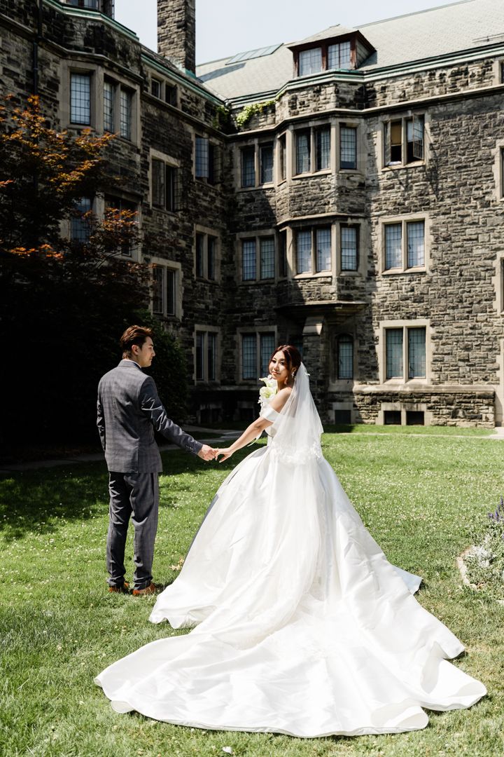 Groom leads bride through Knox College courtyard in romantic wedding photo session.