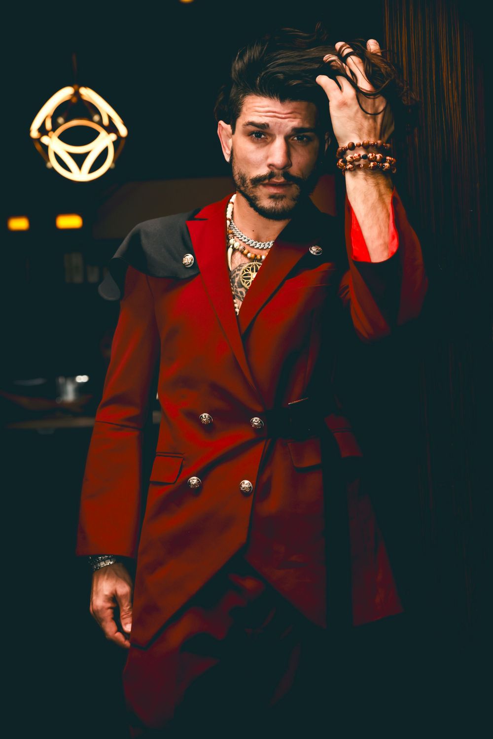 Stylish portrait of man in red double-breasted coat with dramatic lighting.