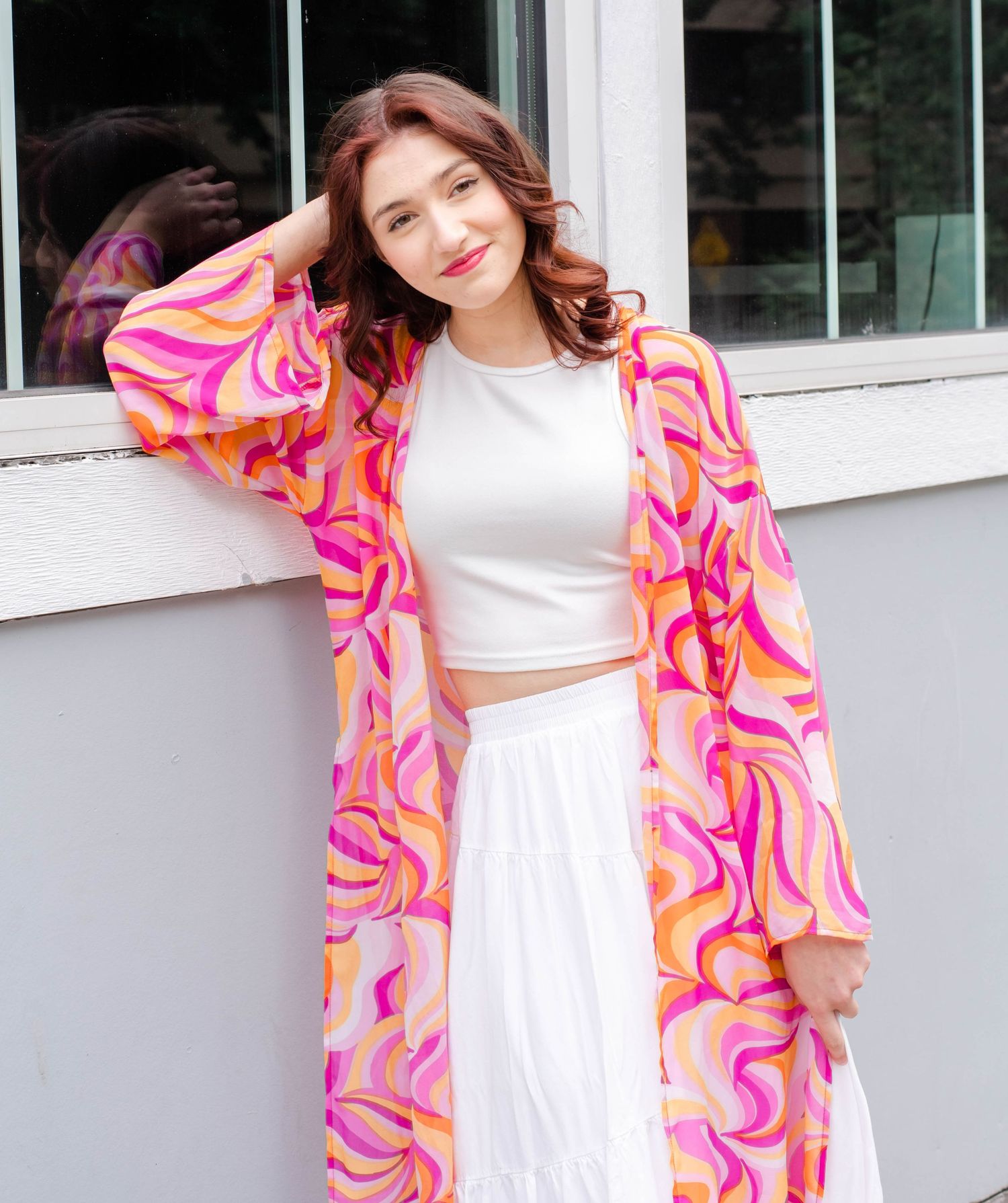 White dress paired with colorful pink and orange patterned cardigan in bright outdoor setting.