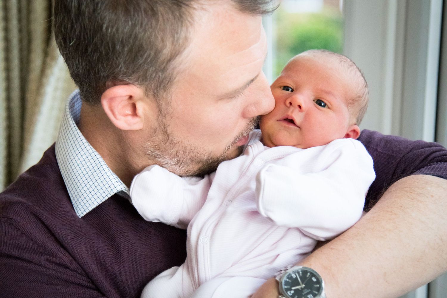 Newborn baby girl having a cuddle with her dad, Ashtead newborn photographer