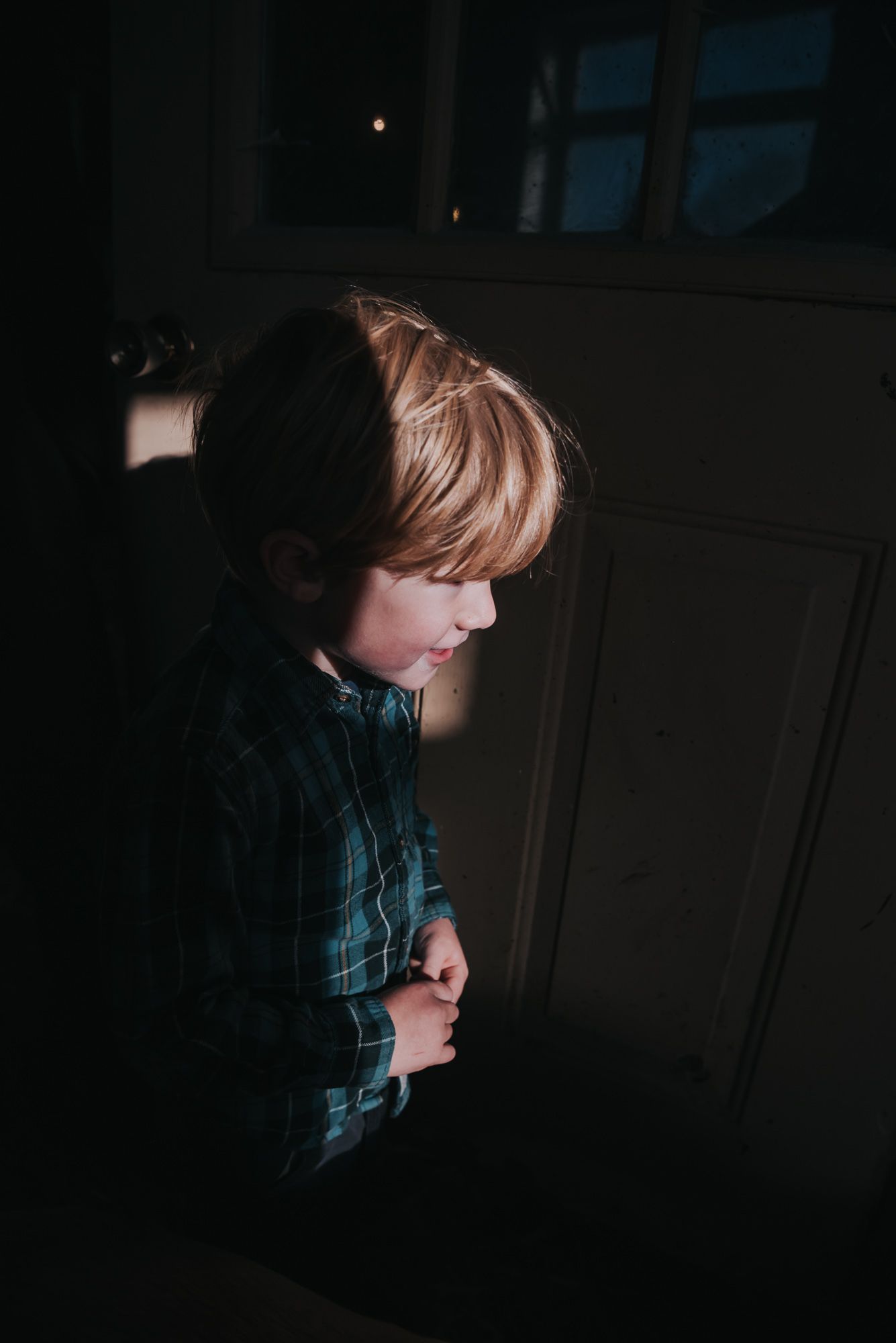 A boy is seen looking at something unseen with a smile on his face.