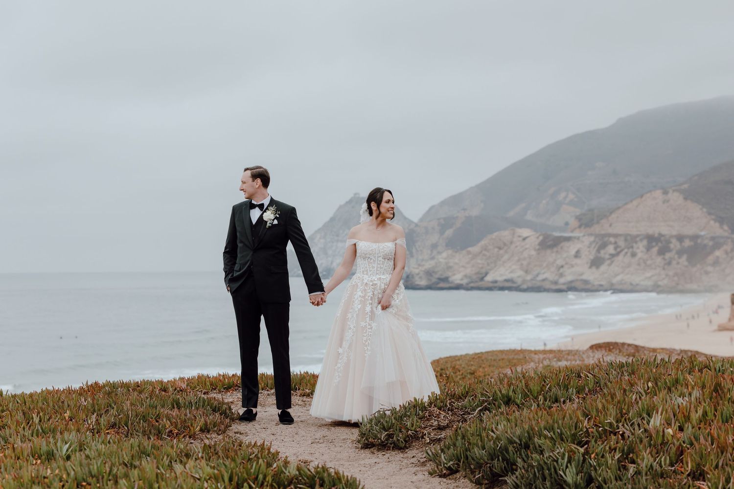 A romantic black and white portrait of a bride and groom sharing an intimate moment under a veil.