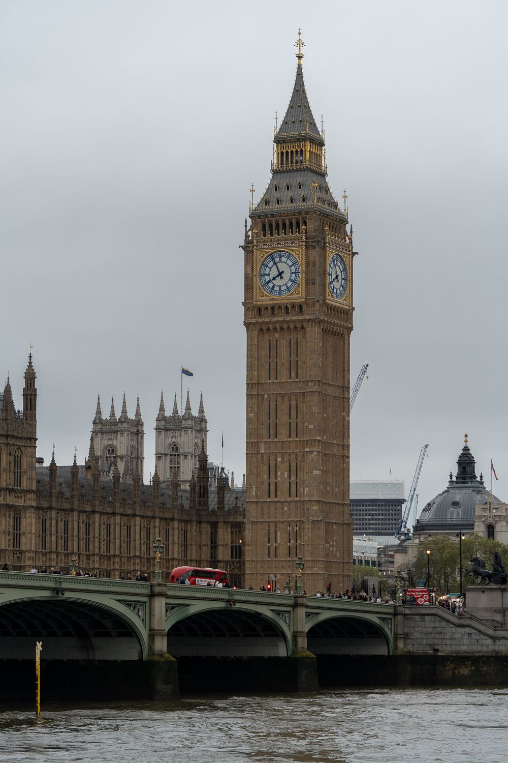 Big Ben clock tower and Houses of Parliament along the Thames River in London.