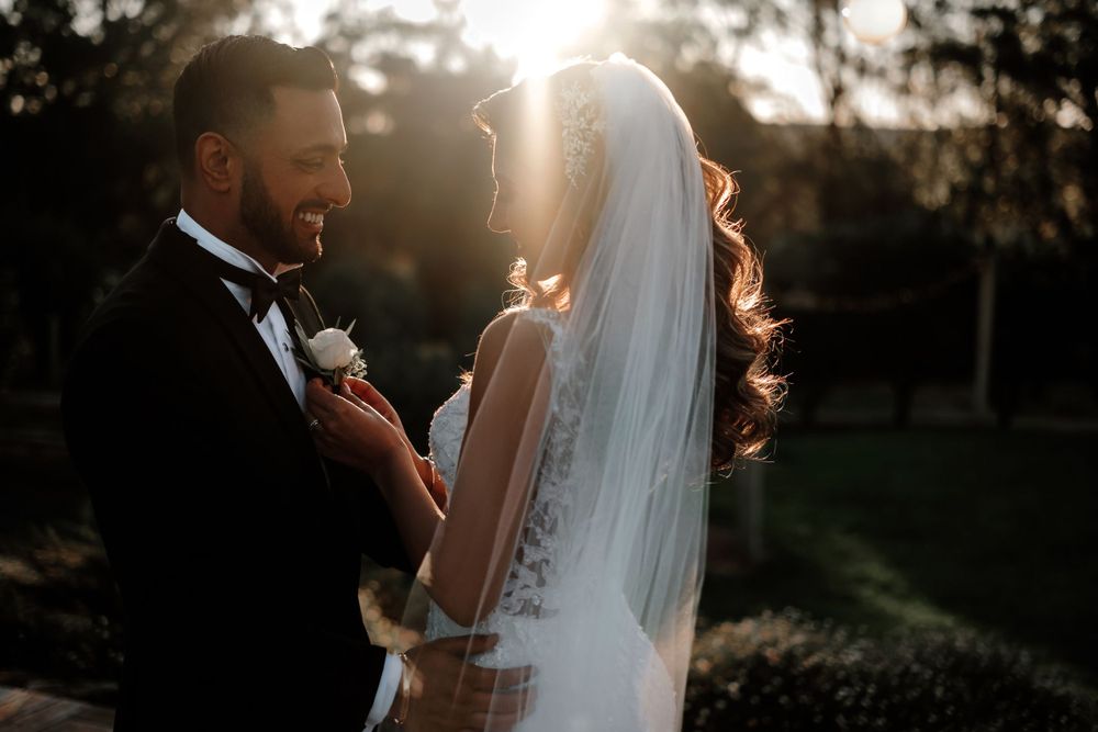 Romantic sunset portrait of newlyweds embracing in golden light.