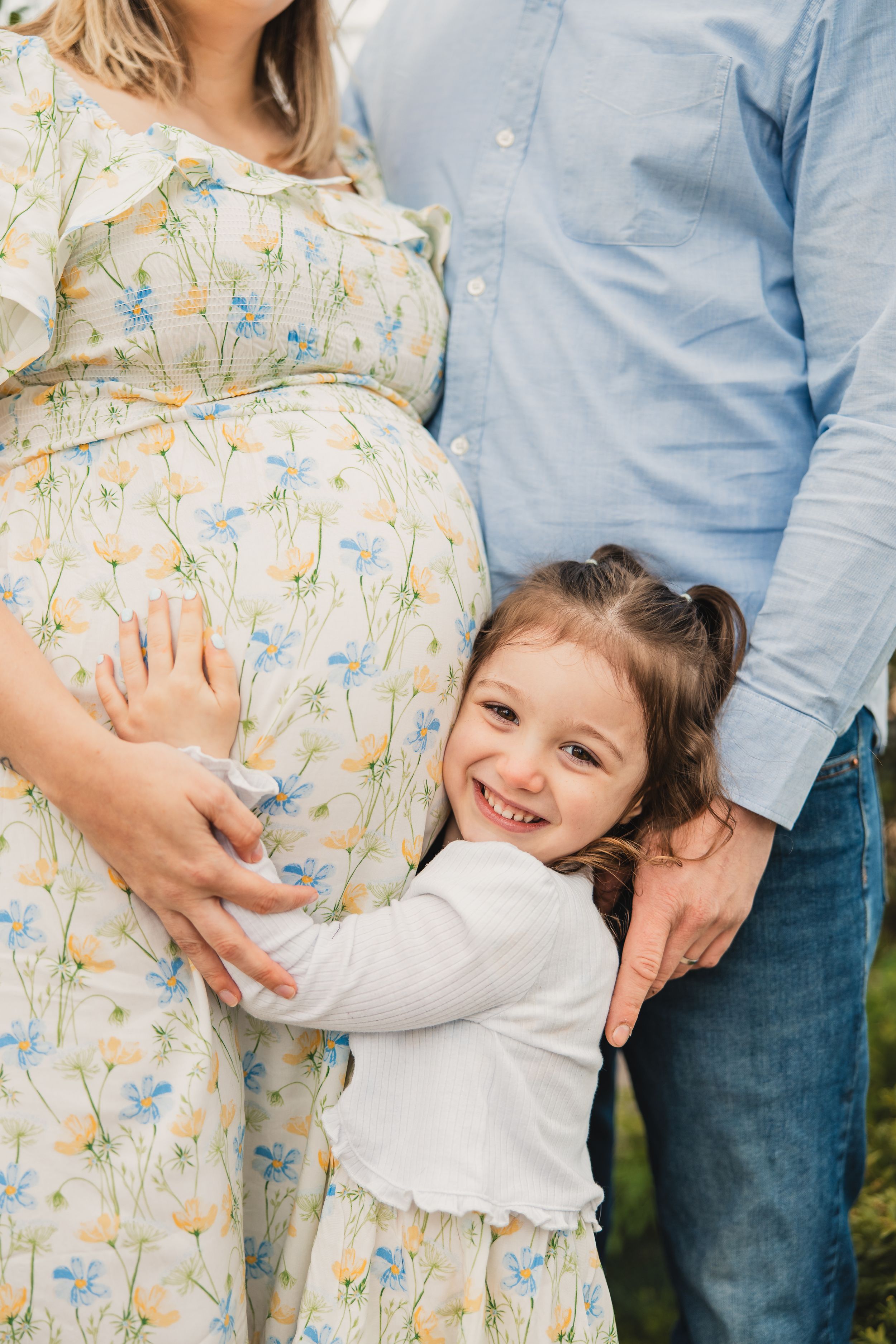 A series of maternity photos showing a family embracing and celebrating a pregnancy in casual outdoor attire.