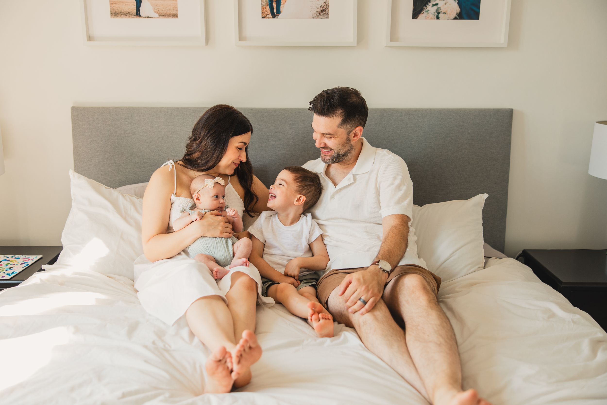 A series of intimate newborn lifestyle photos showing a family of four relaxing together on a large bed.