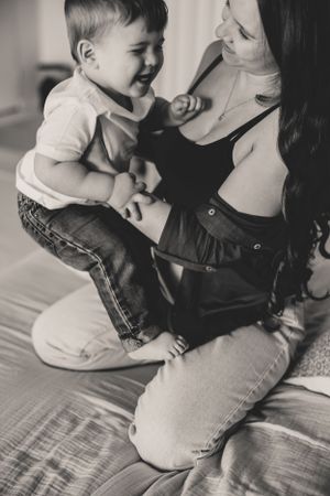 Black and white photo series showing tender moments between parent and baby sitting together on bed.