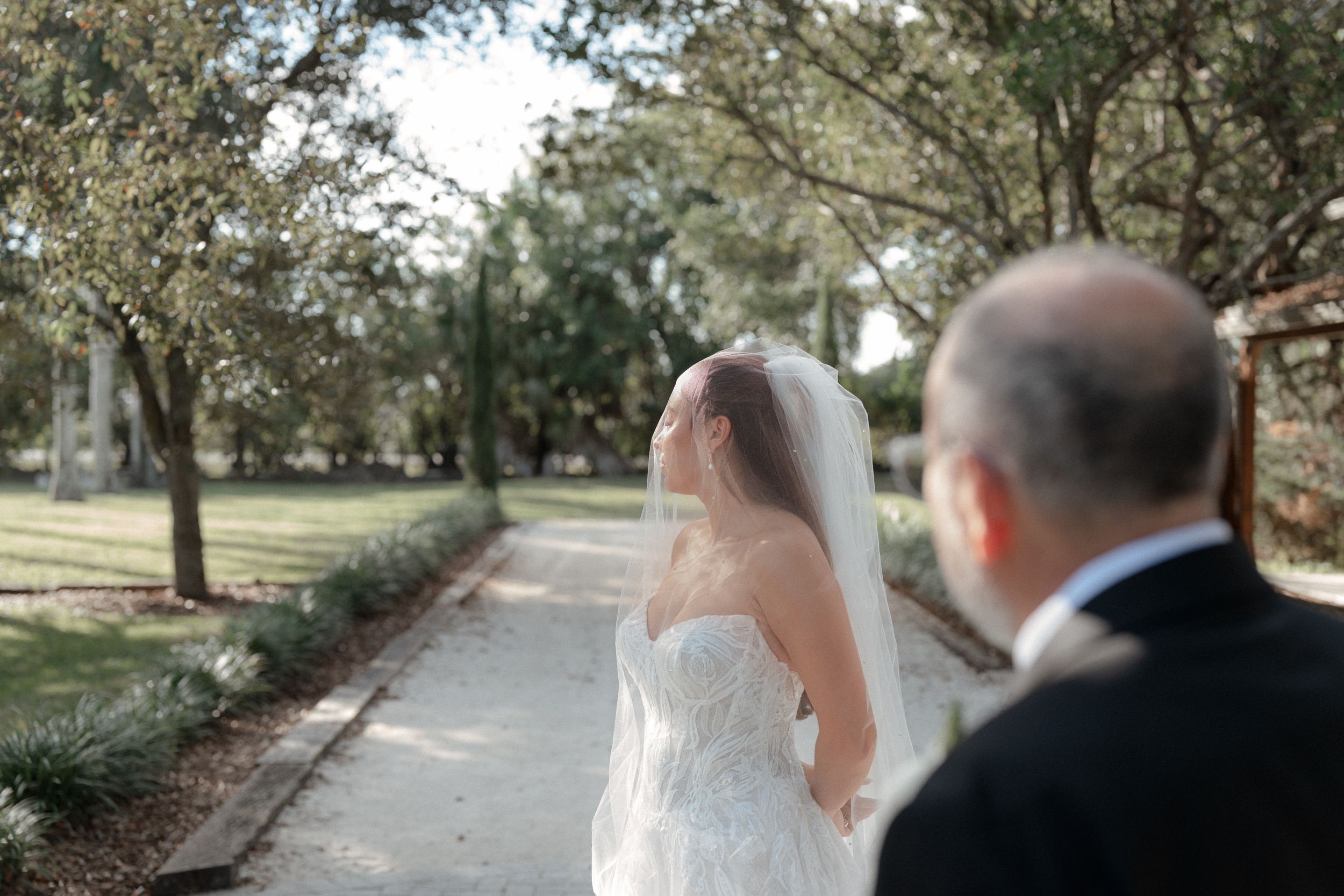 Scenic garden pathway lined with trees creates a romantic outdoor wedding setting.