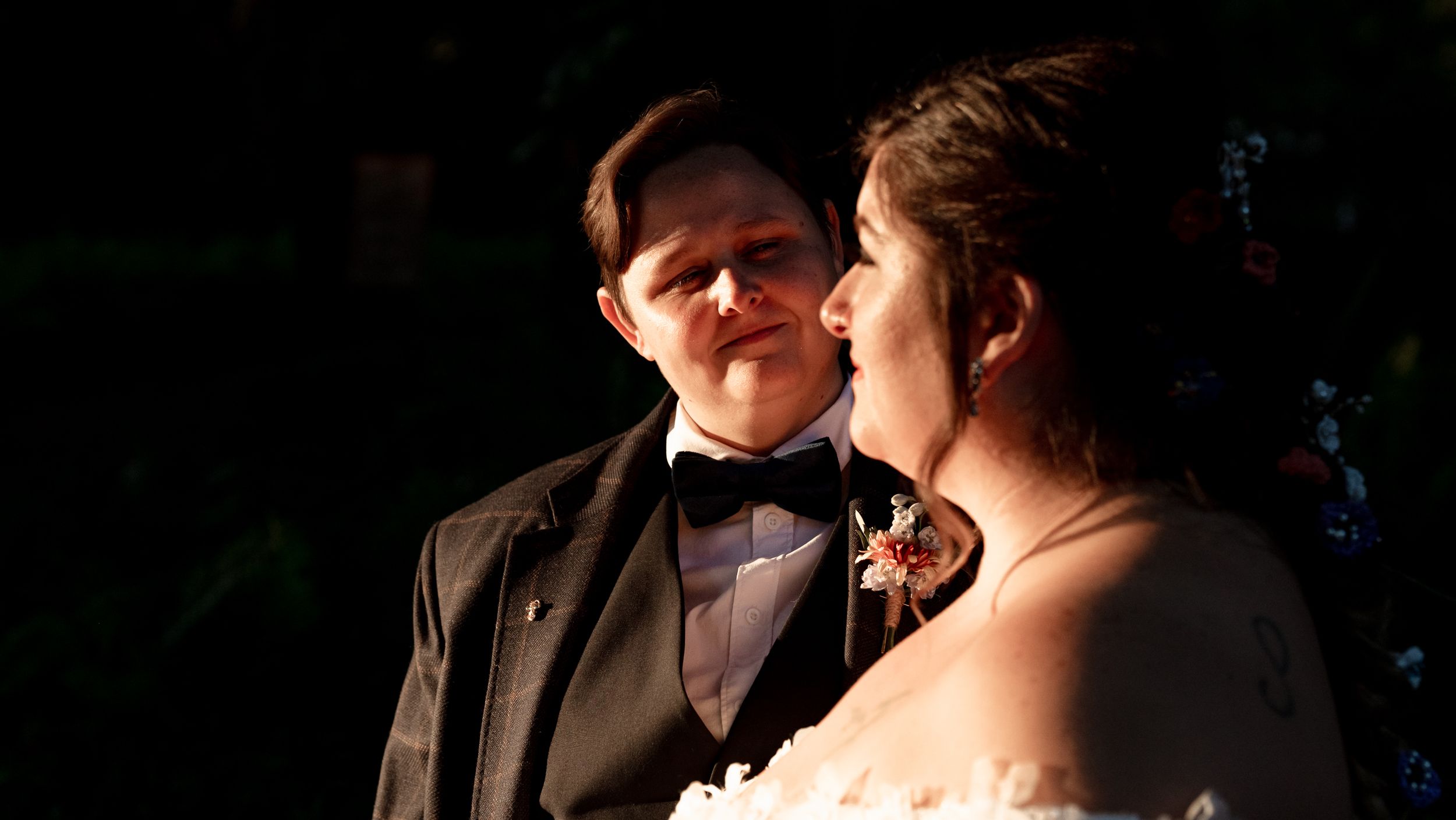 A romantic moment between a couple in formal attire dancing at an elegant evening event.