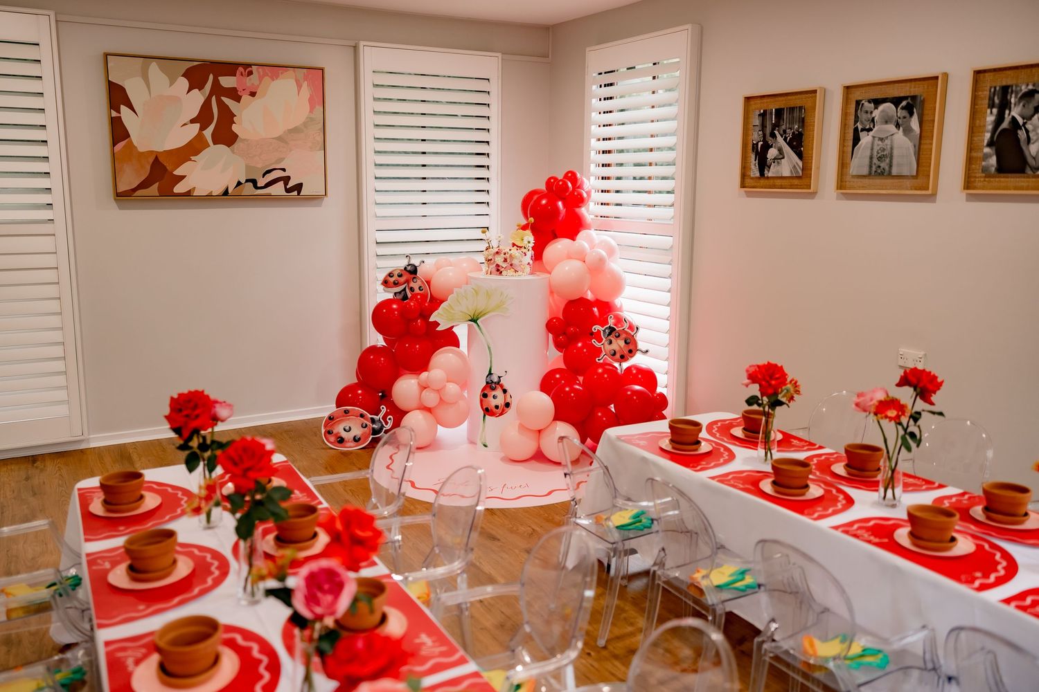 Valentine's themed party setup with red balloon decorations and place settings.