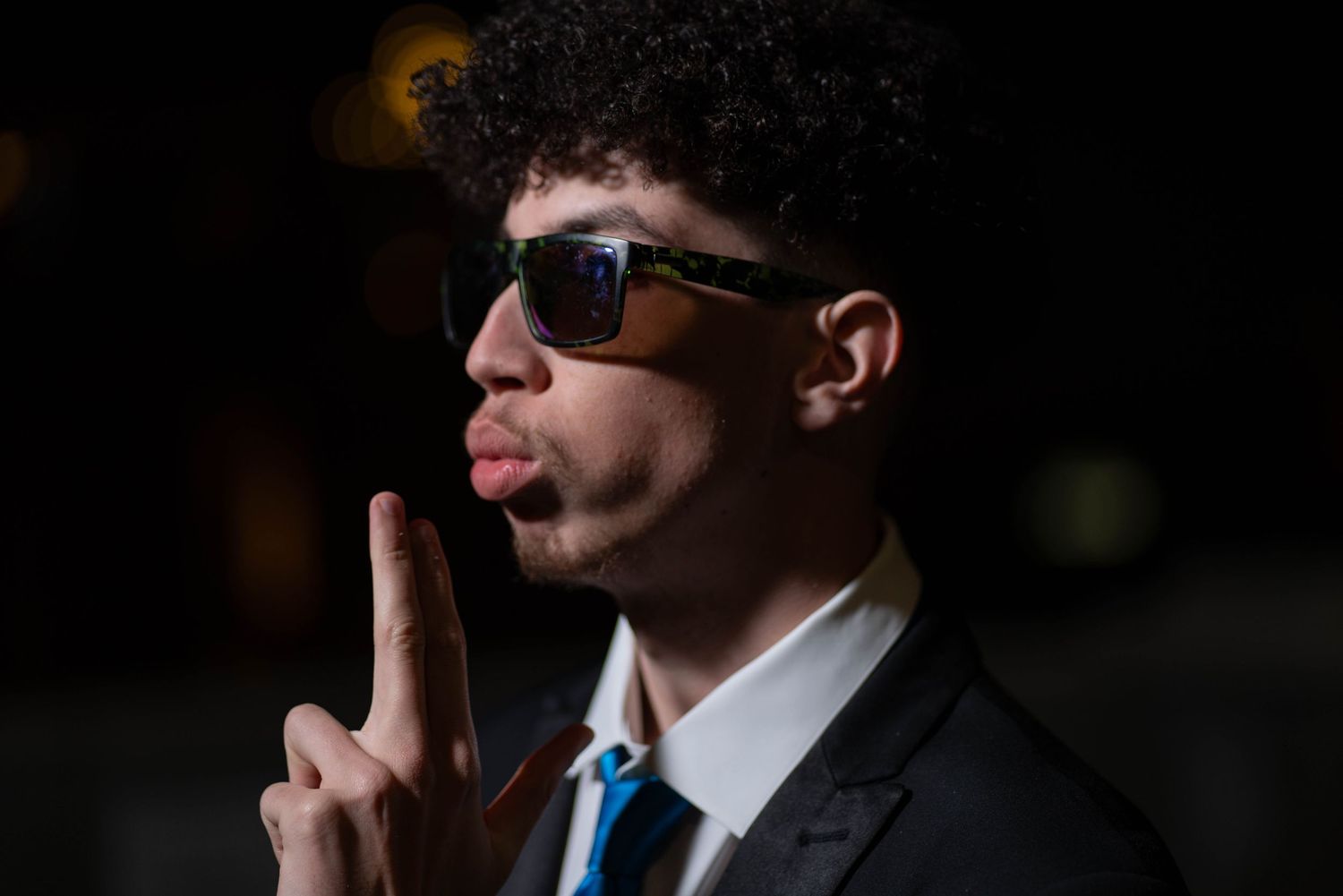 photo of young man blowing his finger tips, prom photo