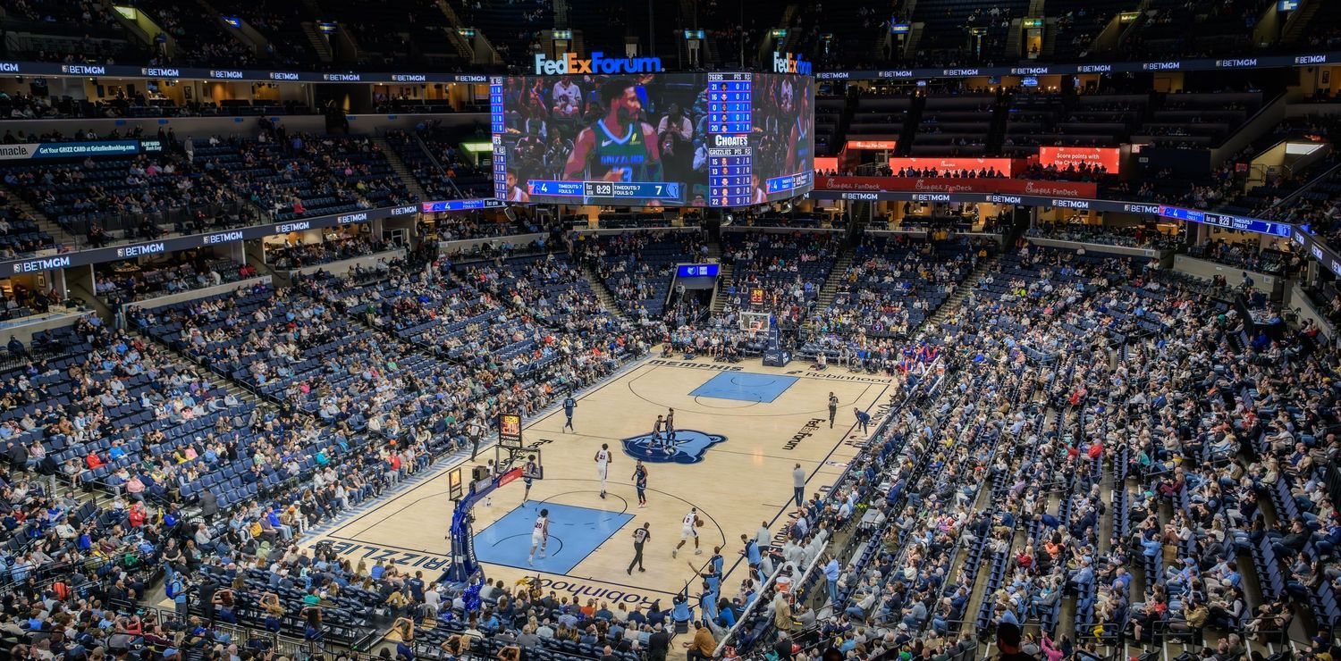 An official NBA Spalding basketball rests on blue stadium seating with blurred background.