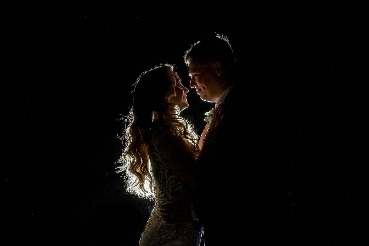 bride and groom romantically backlit