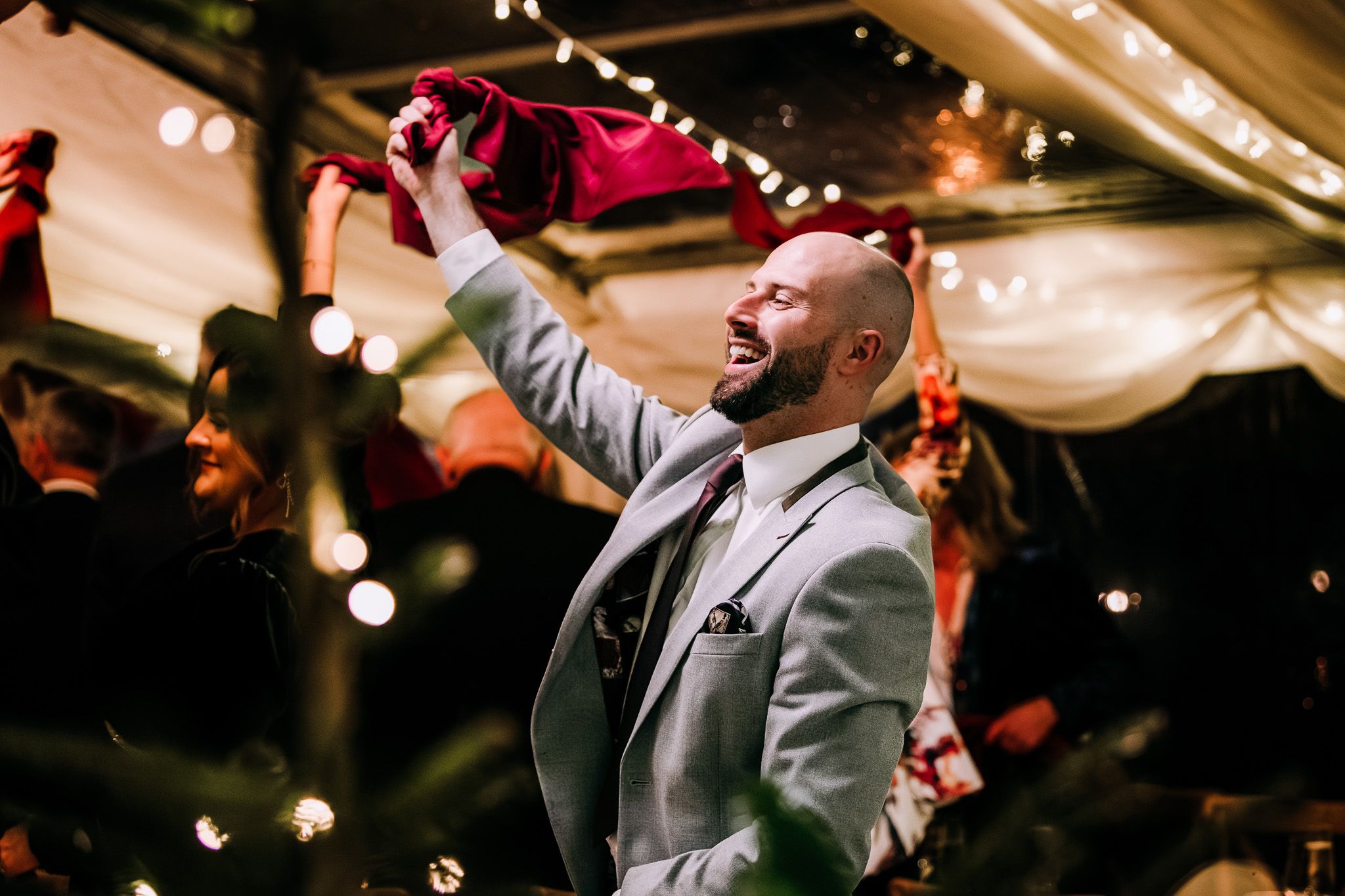 Wedding reception dance party with string lights creating a festive atmosphere.