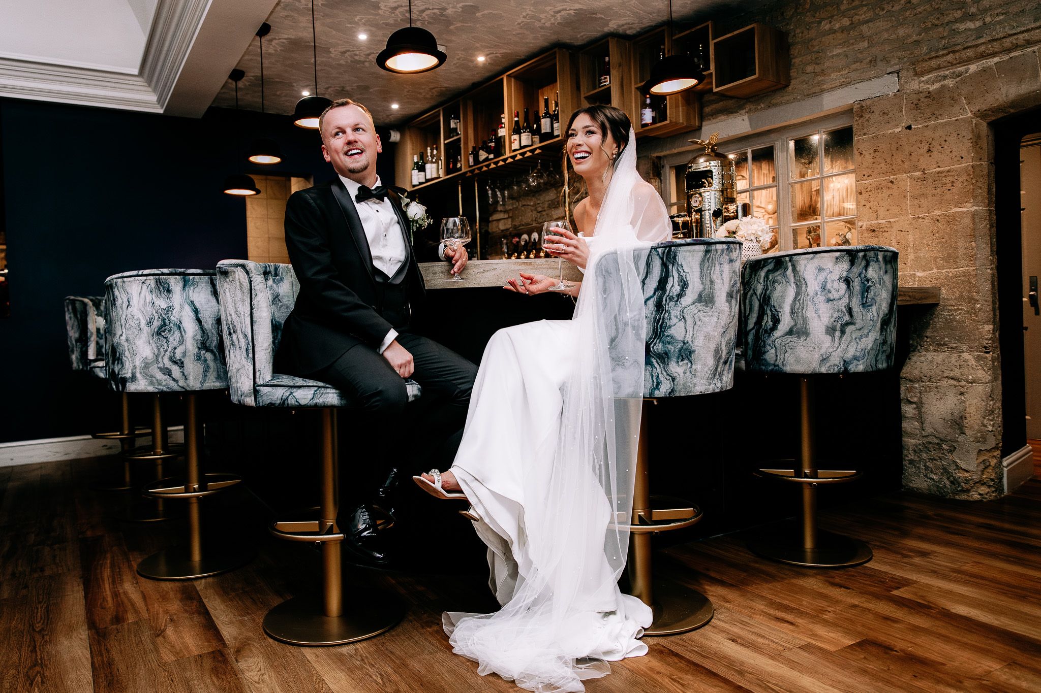 Wedding reception in rustic venue with exposed brick walls and wooden floors.