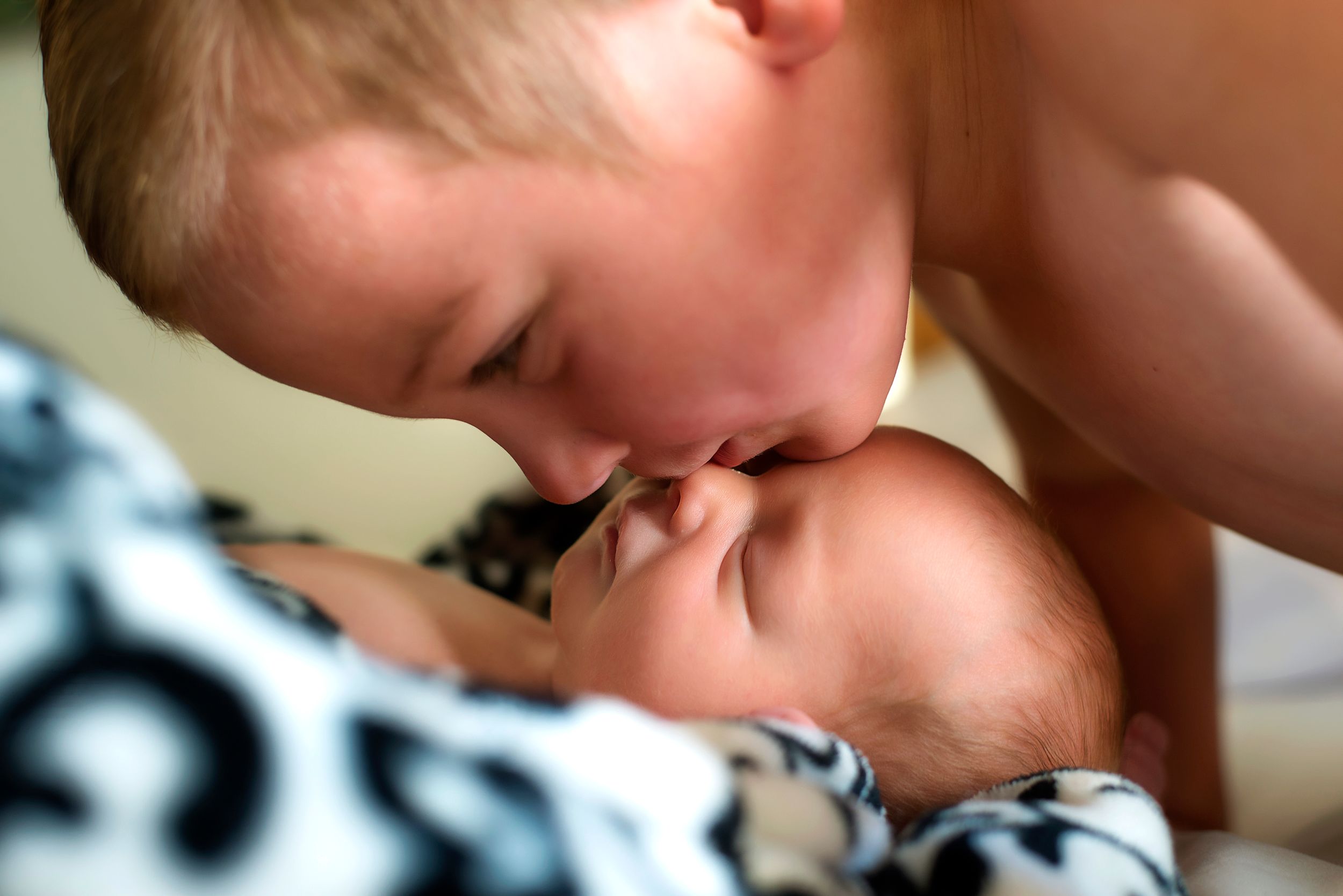 older brother kisses newborn brother on forehead family photography Ellensburg, WA