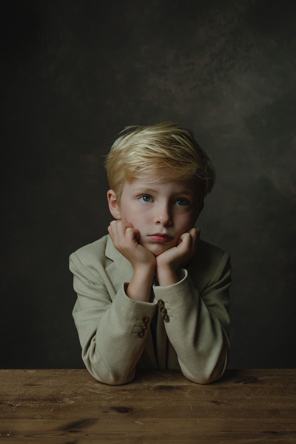 klassiek portret jongetje zittend aan tafel met het rembrandtlicht