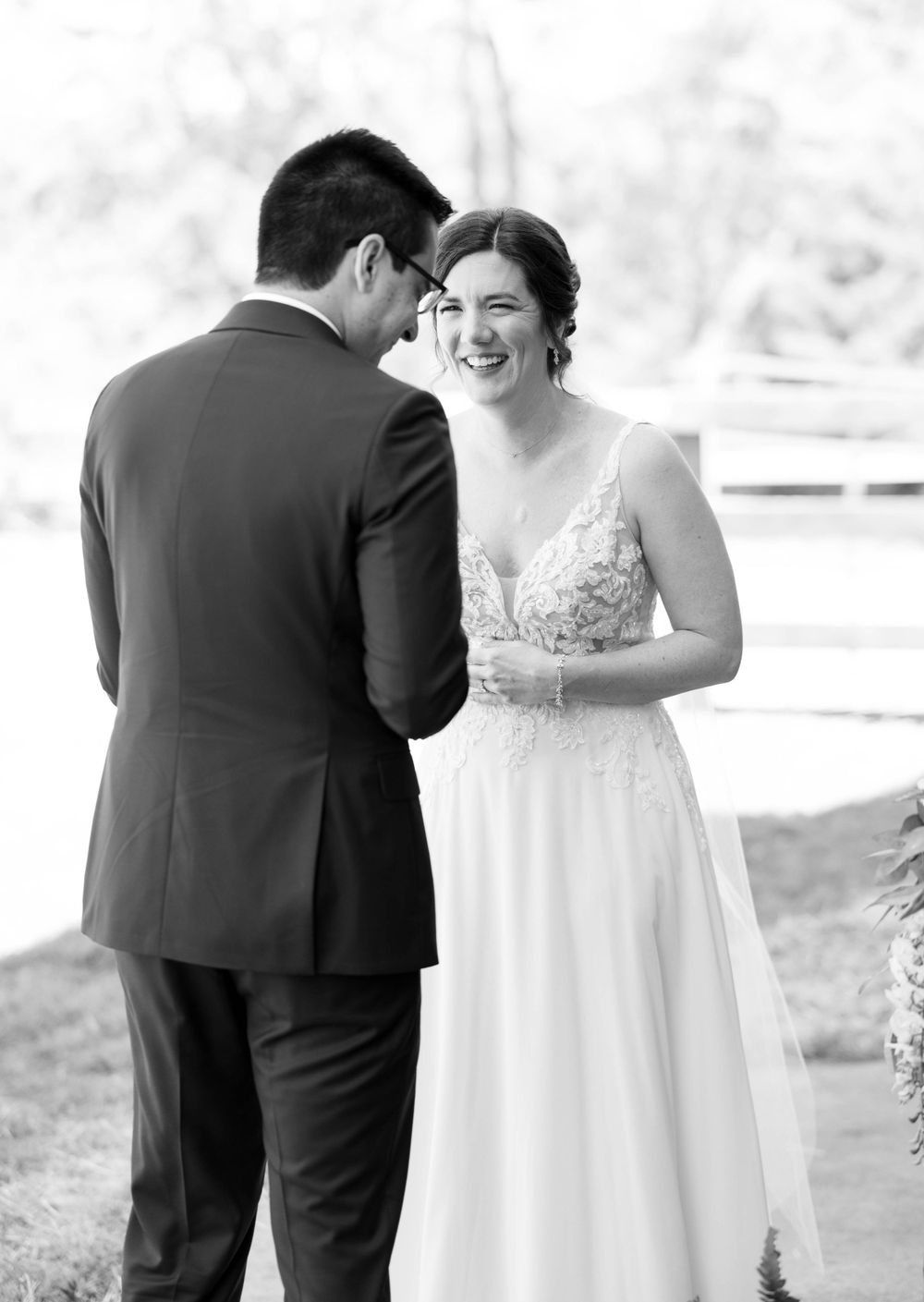 A tender black and white moment between a bride and groom sharing joyful laughter outdoors. The 1932 Barn Venue, Charlotte, NC