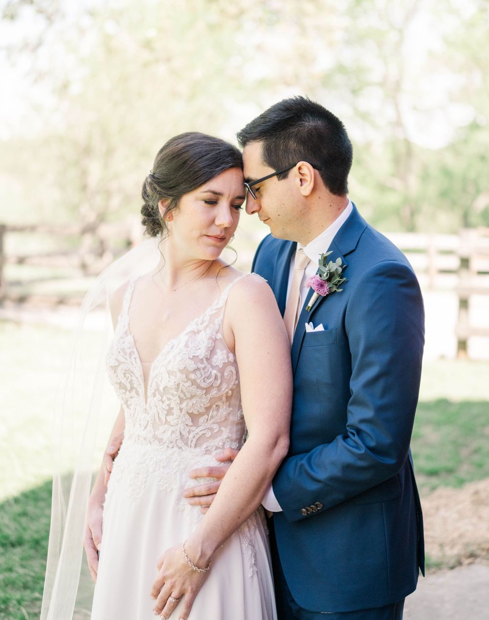 An intimate wedding portrait capturing a gentle moment between newlyweds in a natural setting.