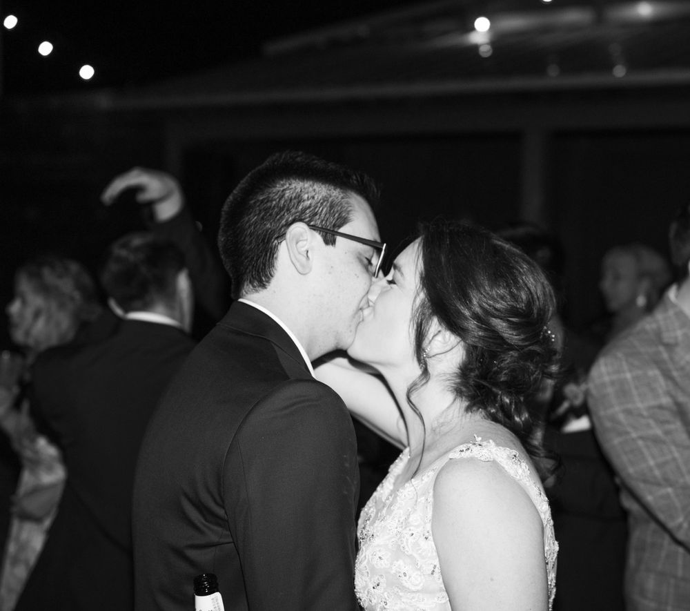 A black and white candid dance floor moment at a wedding reception.