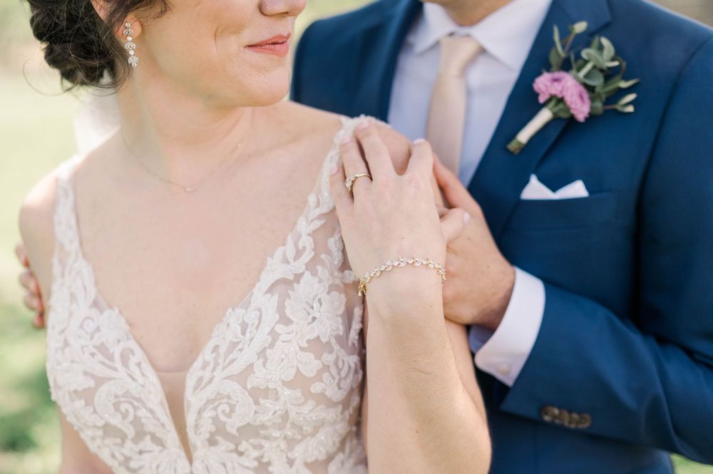 Close-up of delicate lace details and hand placement during wedding portraits. The 1932 Barn Venue, Charlotte, NC