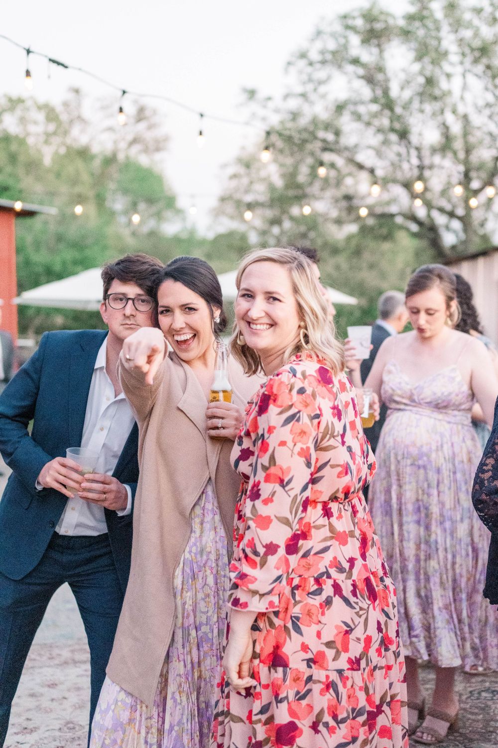 Guests enjoying a festive outdoor celebration with string lights and colorful attire.