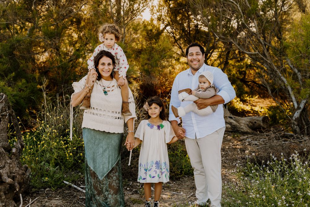 Family picture where everybody looking at the camera and holding hands.
