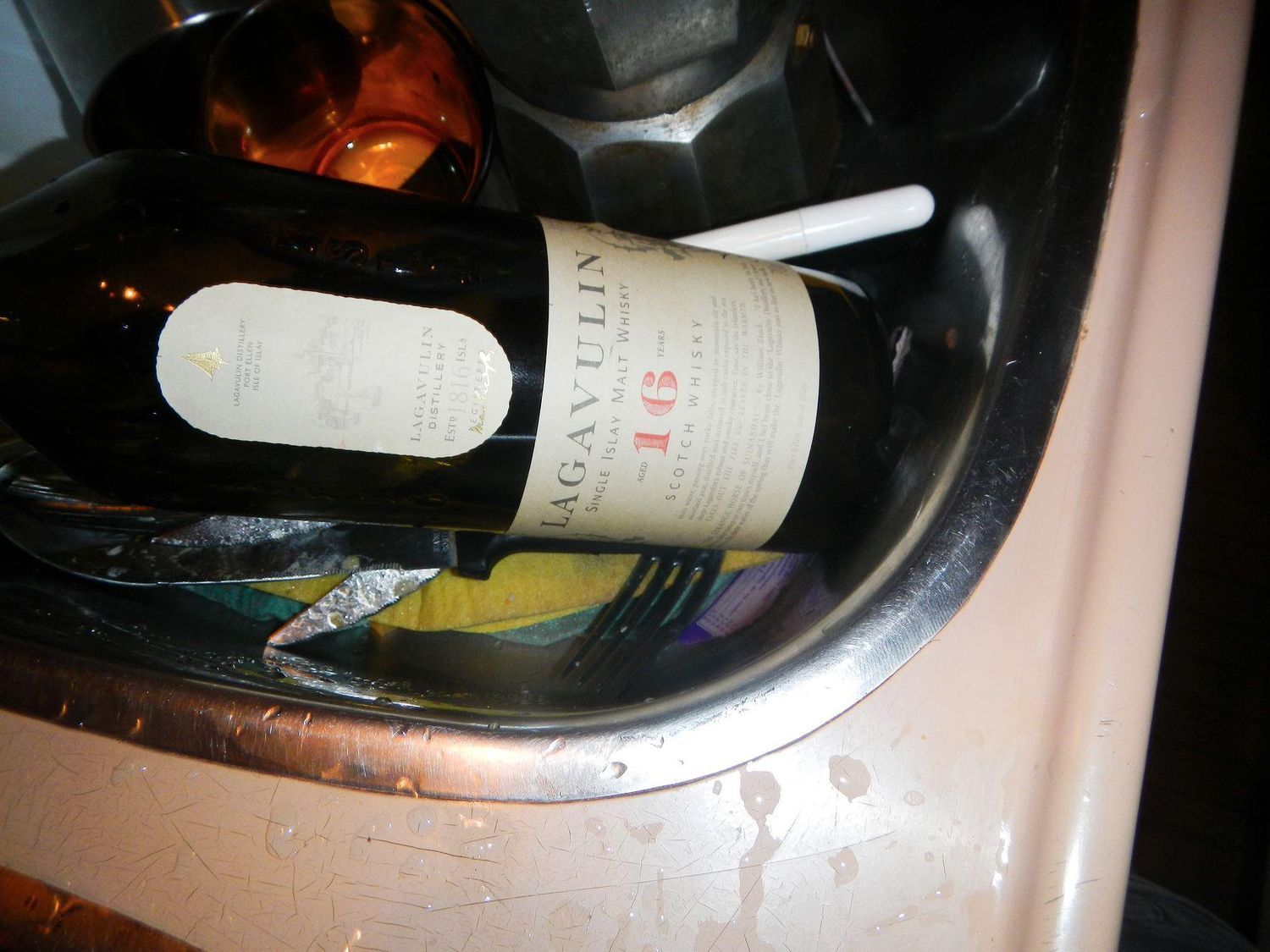Close-up shot of a wine bottle in a boat's galley sink.