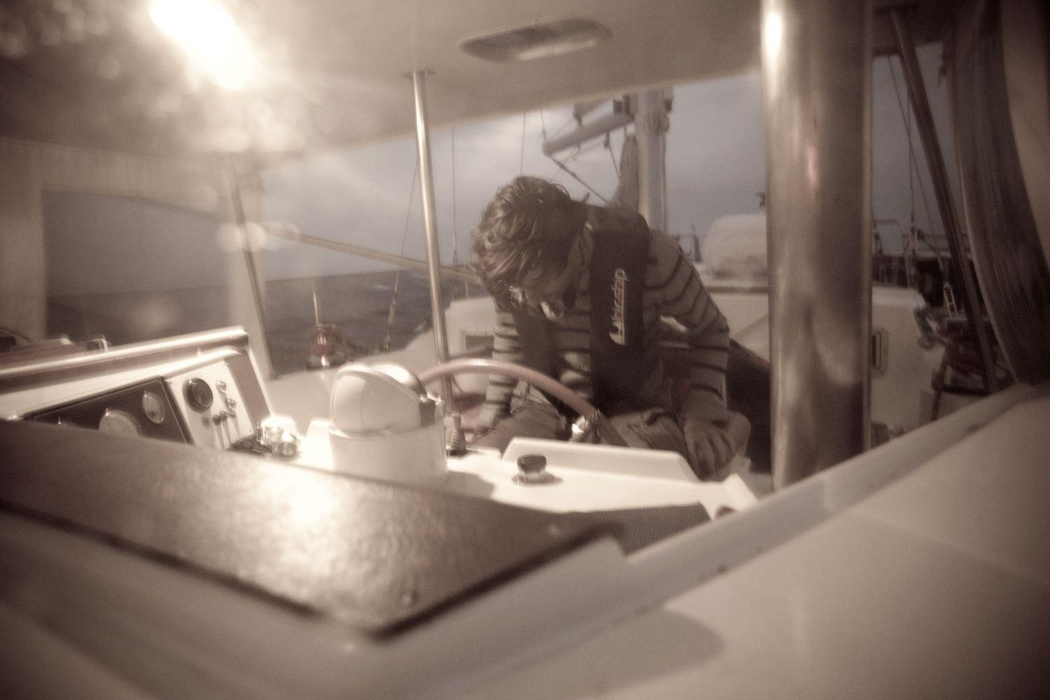 Sepia-toned image of sailing equipment and rigging on boat deck.