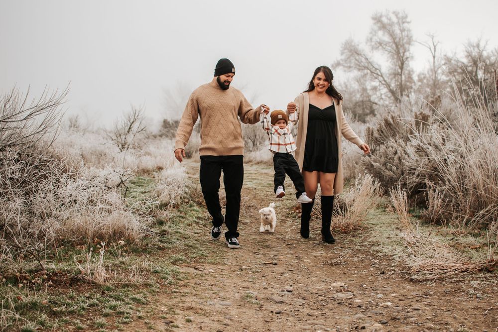 Family walking together with their child and dog on a rustic trail through winter brush in Tri Cities, Washington.