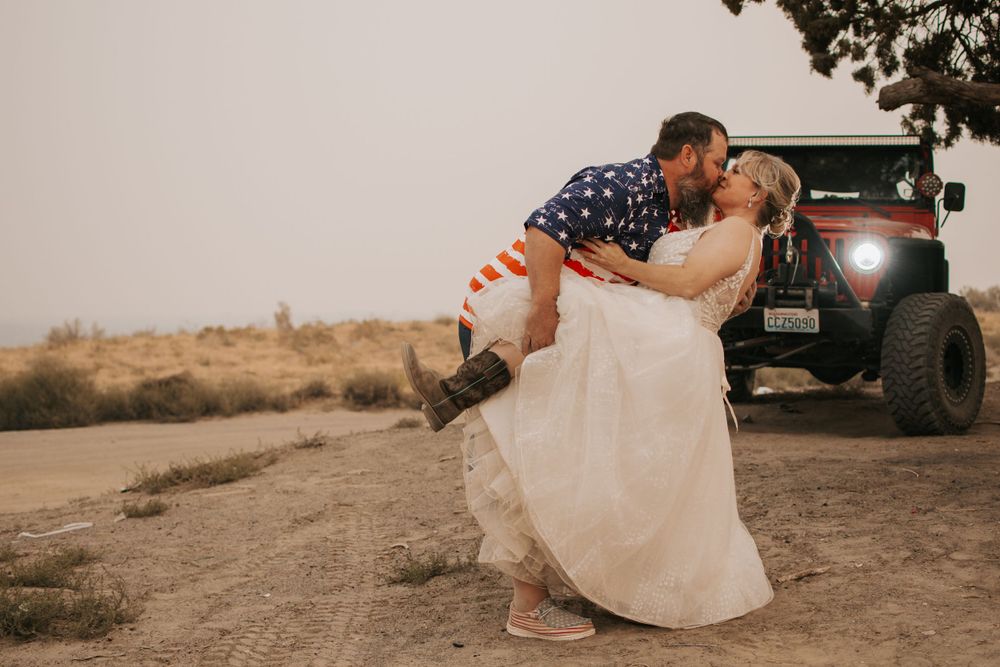 Newlyweds sharing romantic moment in front of Jeep during desert wedding in Pasco, Washington at Juniper Dunes.