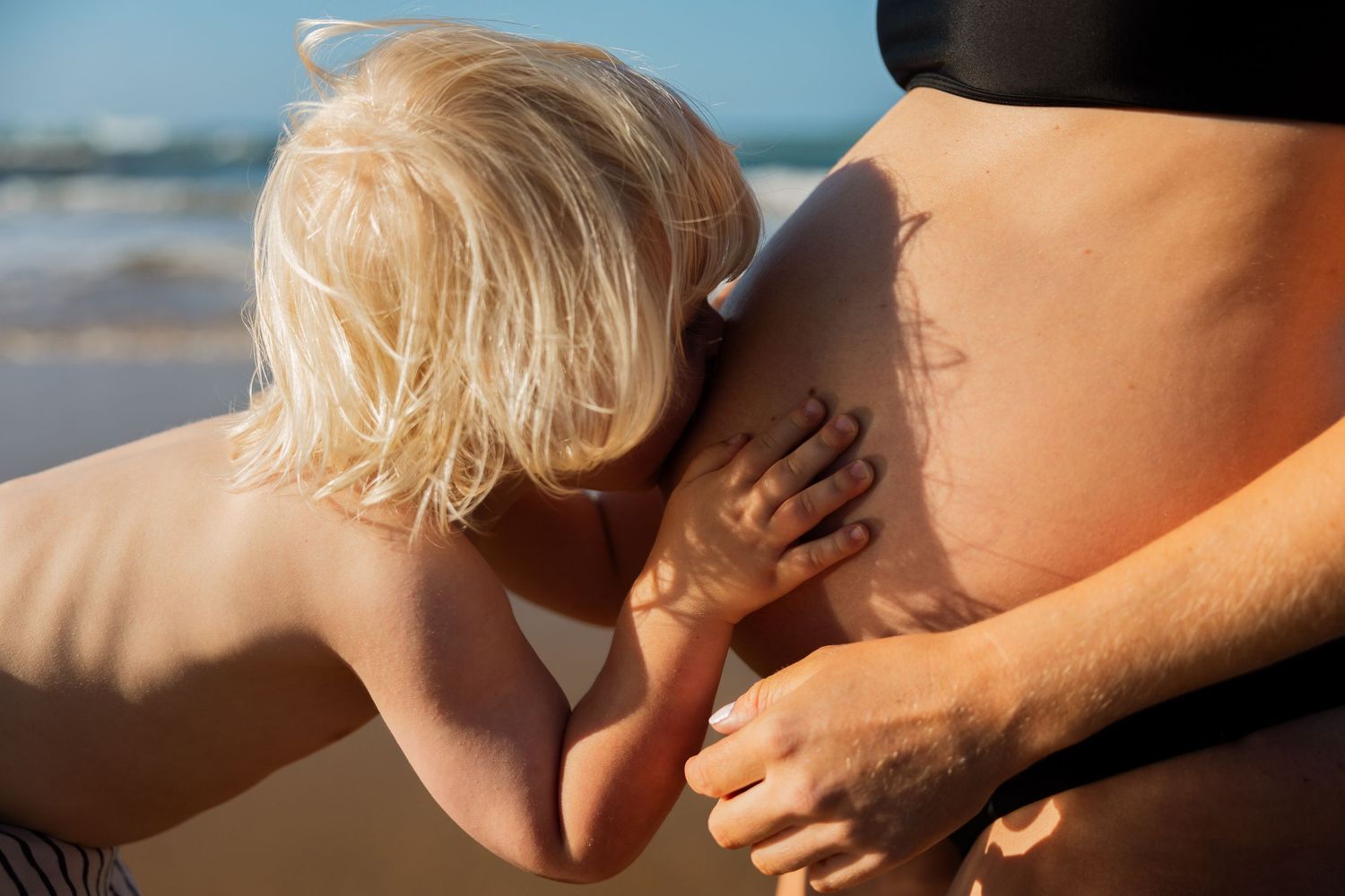 A beautiful little boy kissing his mum's pregnant tummy, a beautiful big brother already.