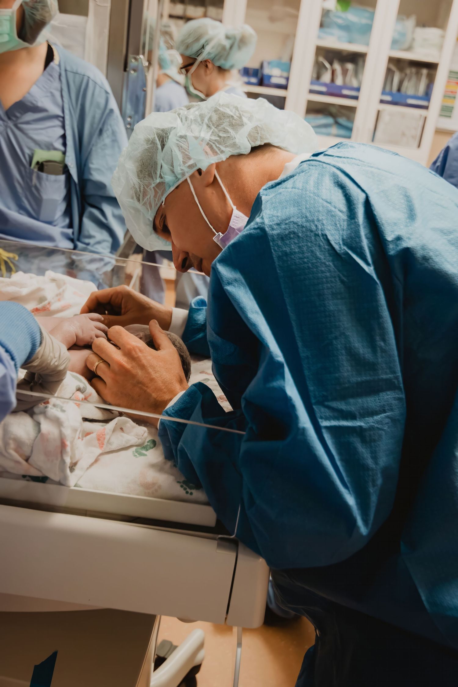 Dental healthcare workers in scrubs and protective gear performing treatment.