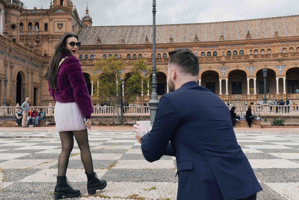 Proposal moment captured at Plaza de España in Seville with historic architecture in background.