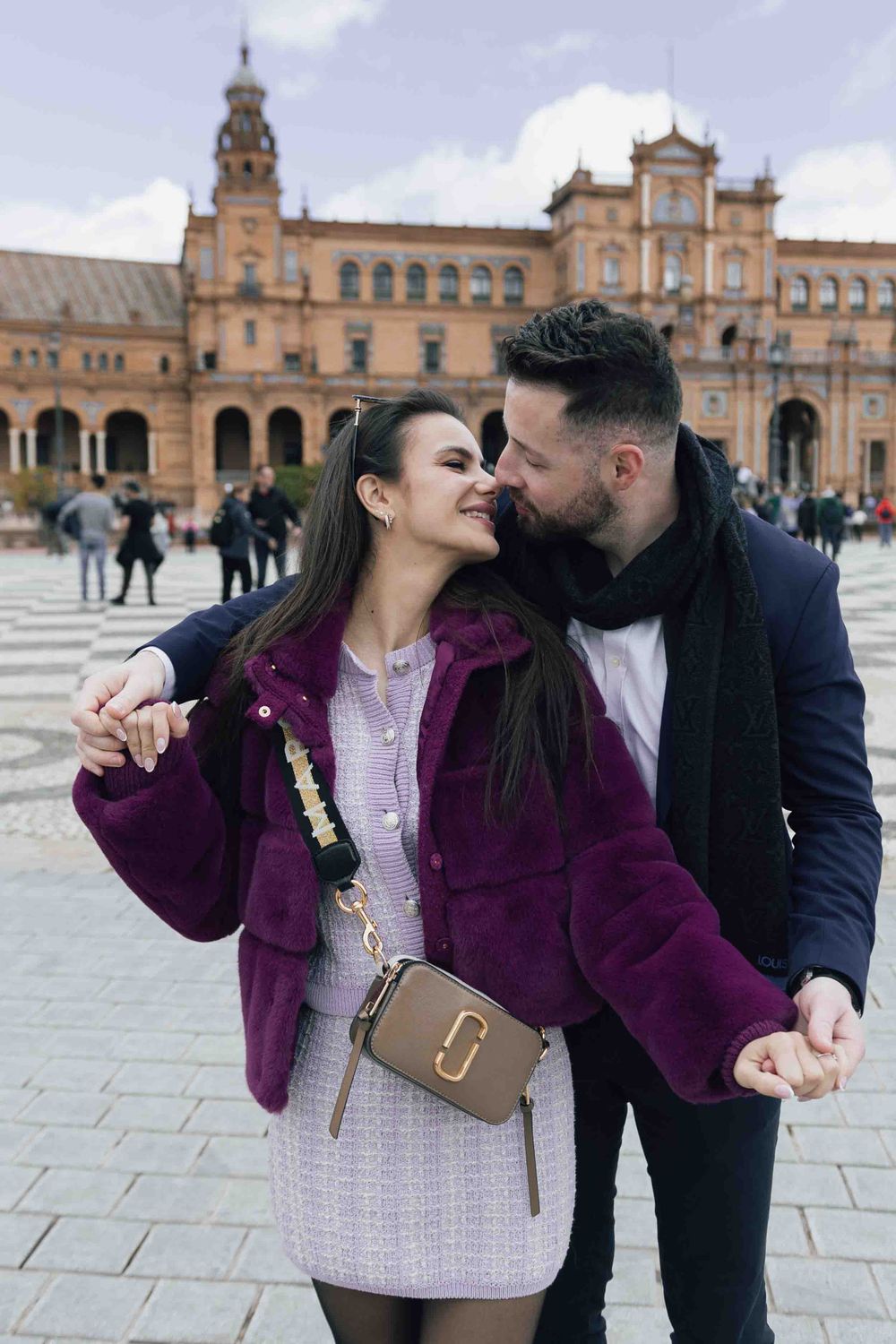 Romantic embrace in front of the historic Plaza de España building in Seville.