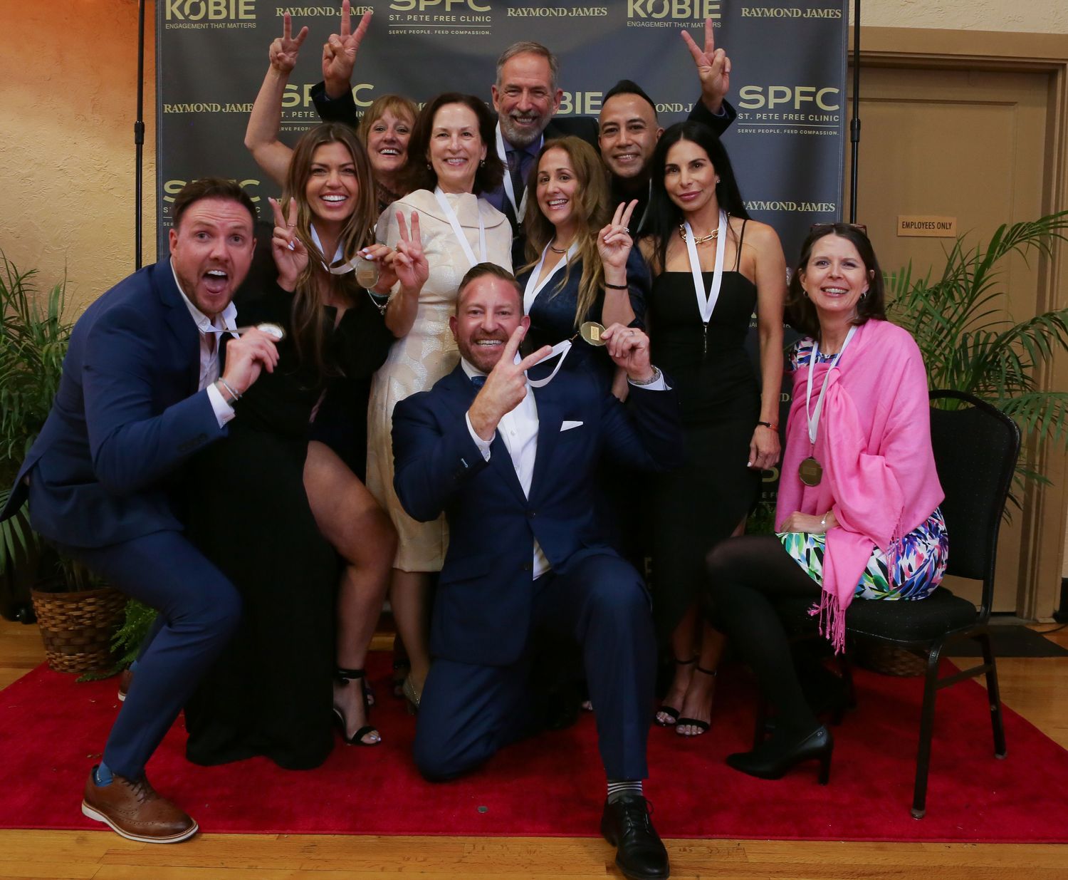 group of coworkers goofing around at step and repeat st petersburg fl