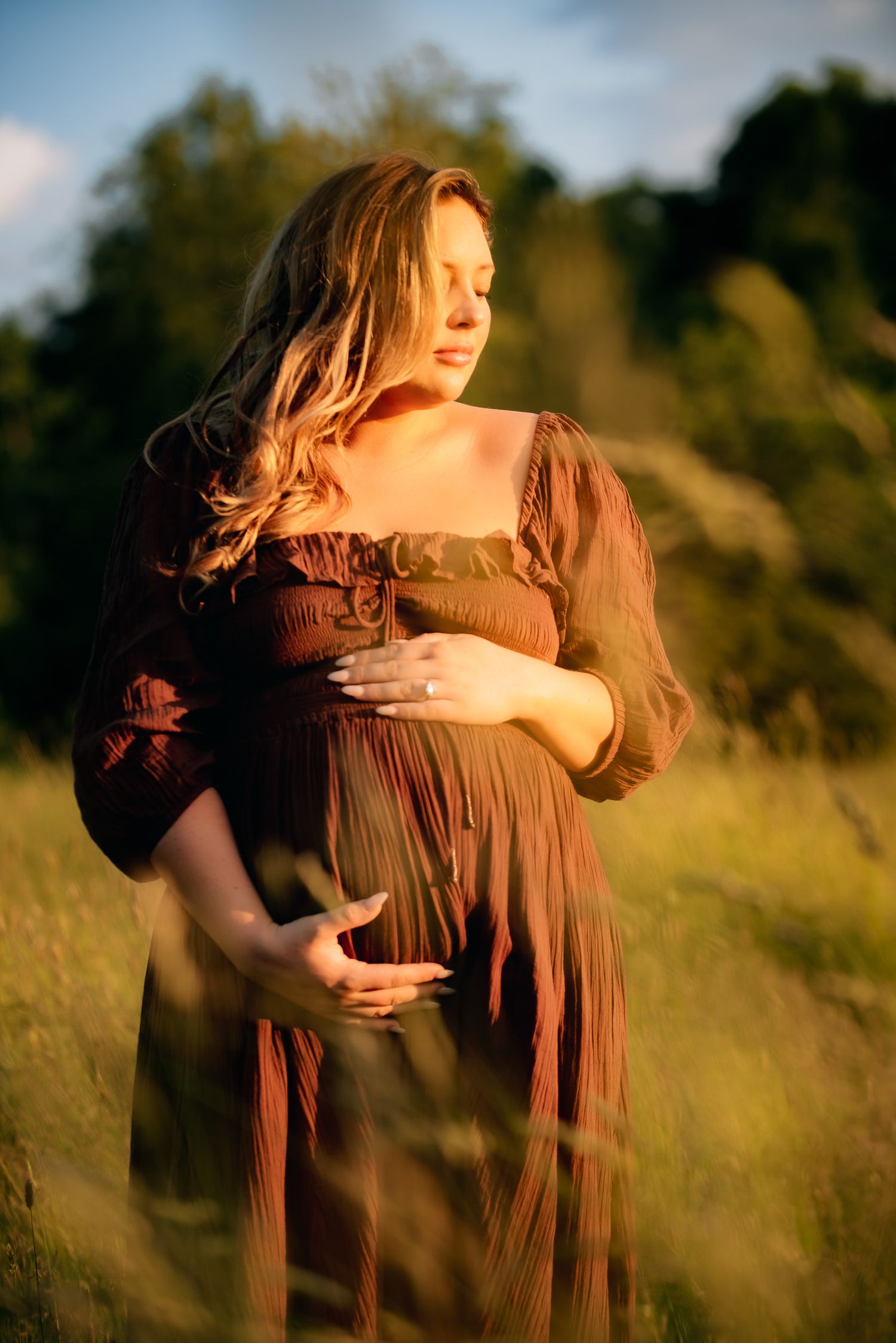 pregnant mama in meadow at sunset posing for outdoor photoshoot in Westborough Massachusetts