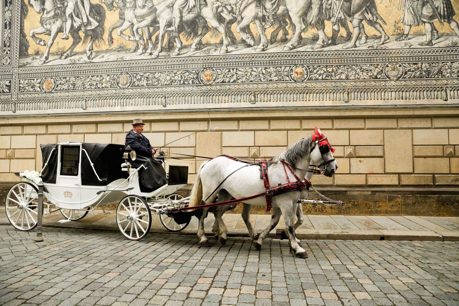 Horse-drawn white carriage rides along cobblestone street in historic city showing four connected touristic scenes.