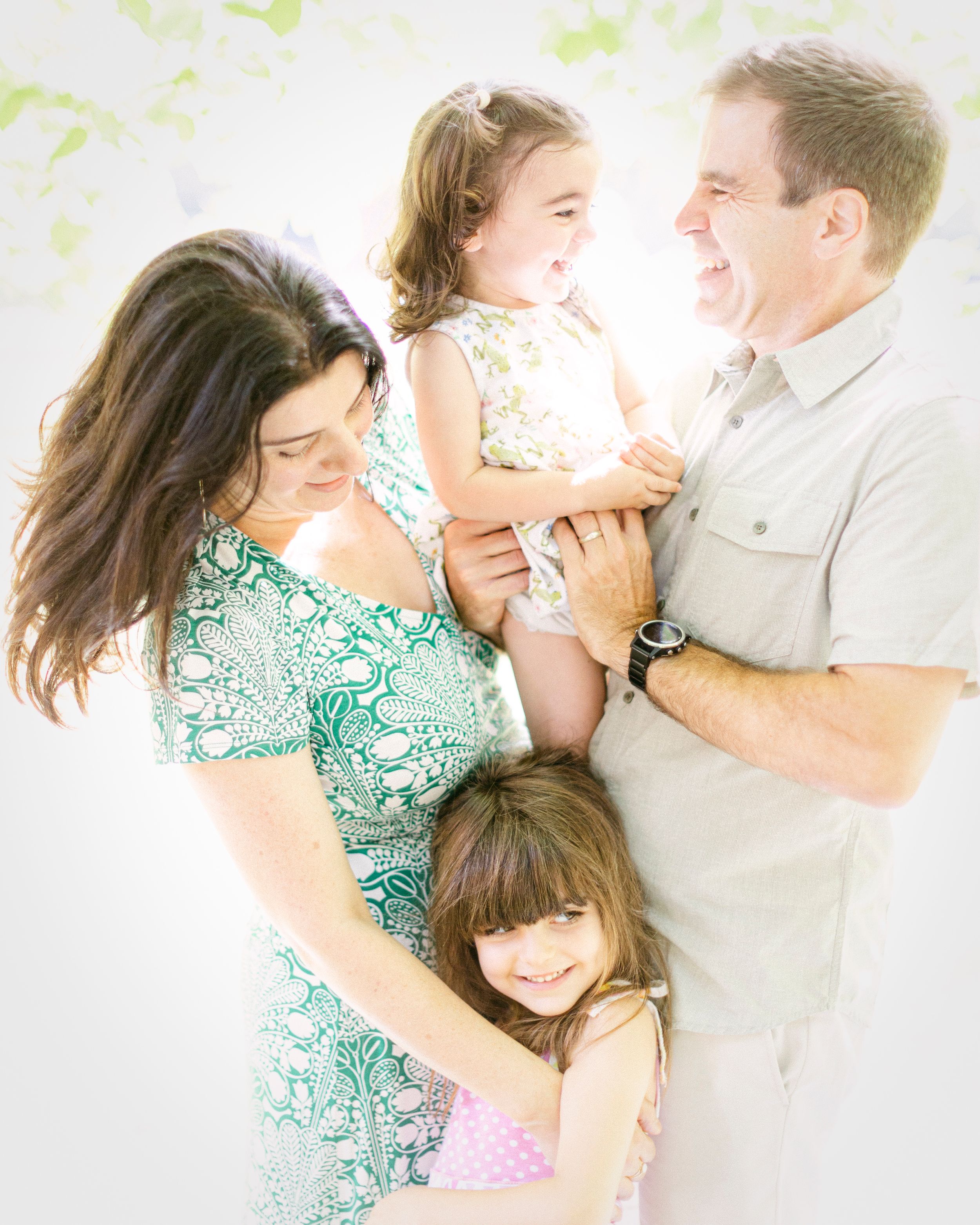 A candid family photo showing pure joy and laughter in matching mint green and white outfits.