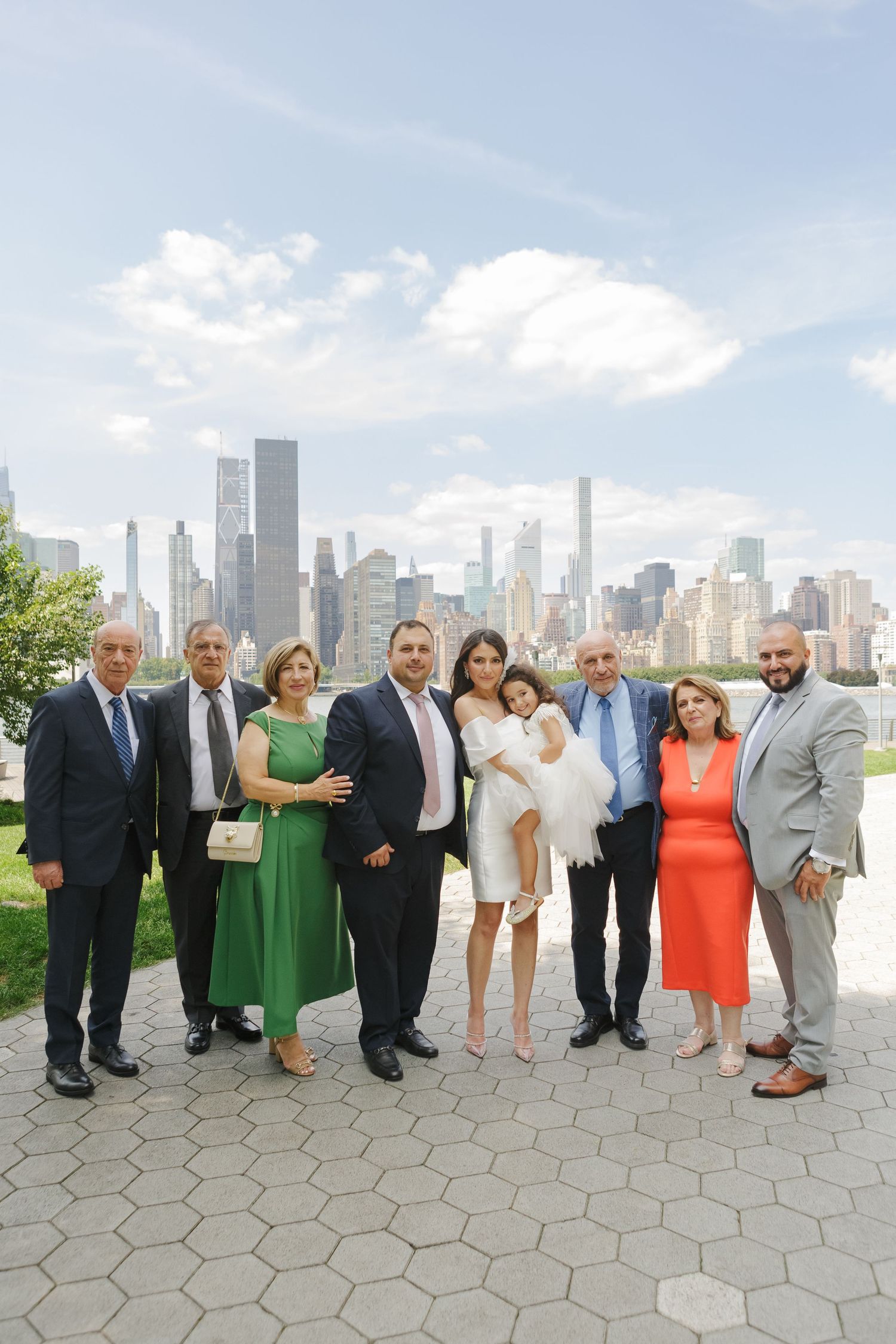Family portrait with NYC skyline in the background at Long Island City, by NYC family photographer Paula Ortiz