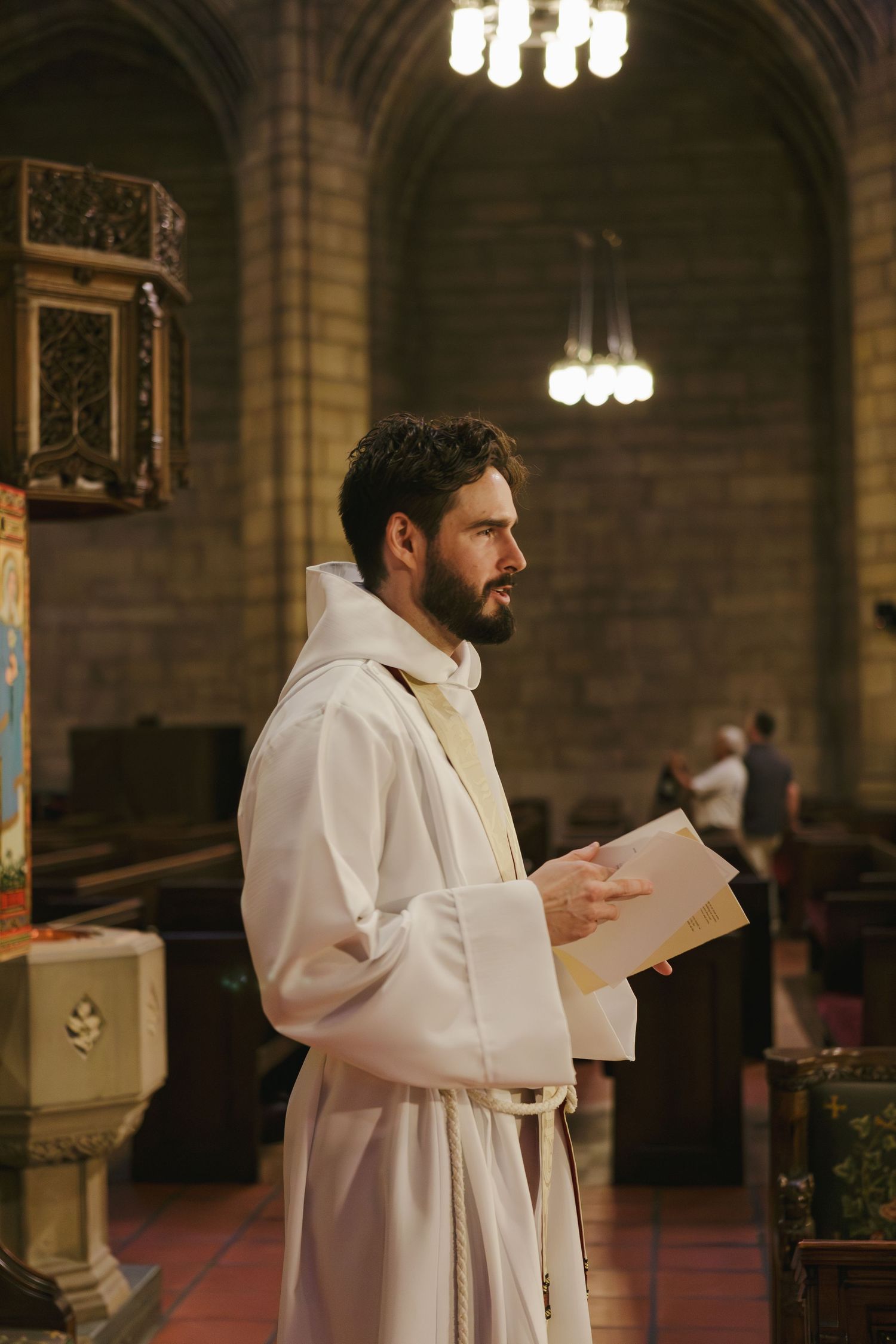 Candid of priest preaching during baptism at St. Thomas Church Fifth Avenue NYC