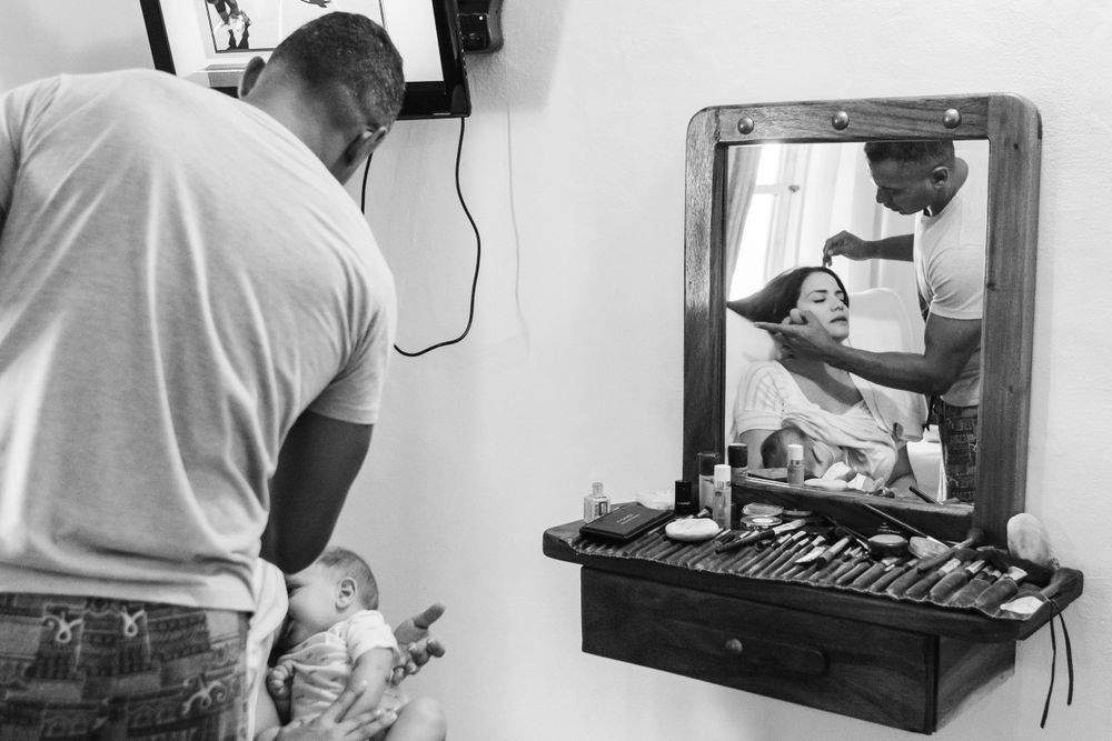 Family preparing for the baptism, getting makeup done by NYC family photographer Paula Ortiz