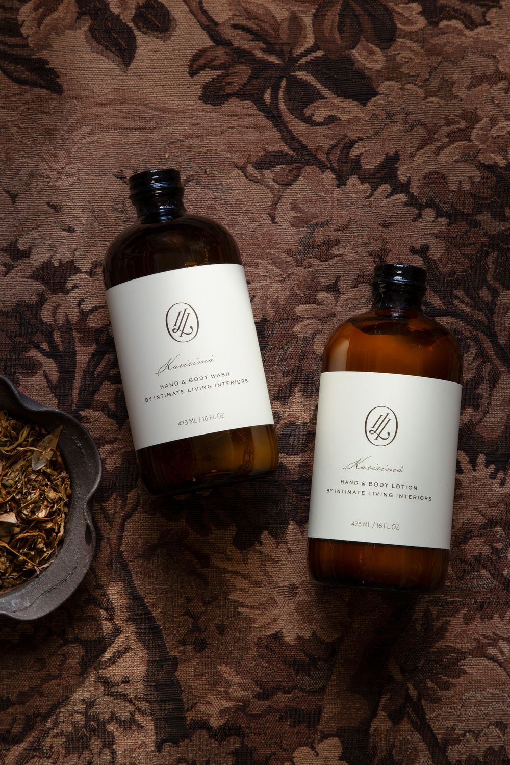 Amber glass bottles with minimalist white labels arranged on dark wooden surface with textured patterns.