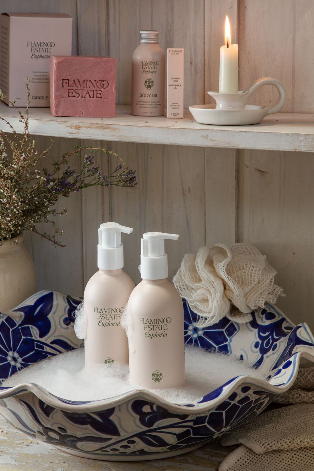 Elegant spa bathroom display featuring Diamond Estate toiletries on a blue and white ceramic dish with a lit candle accent.