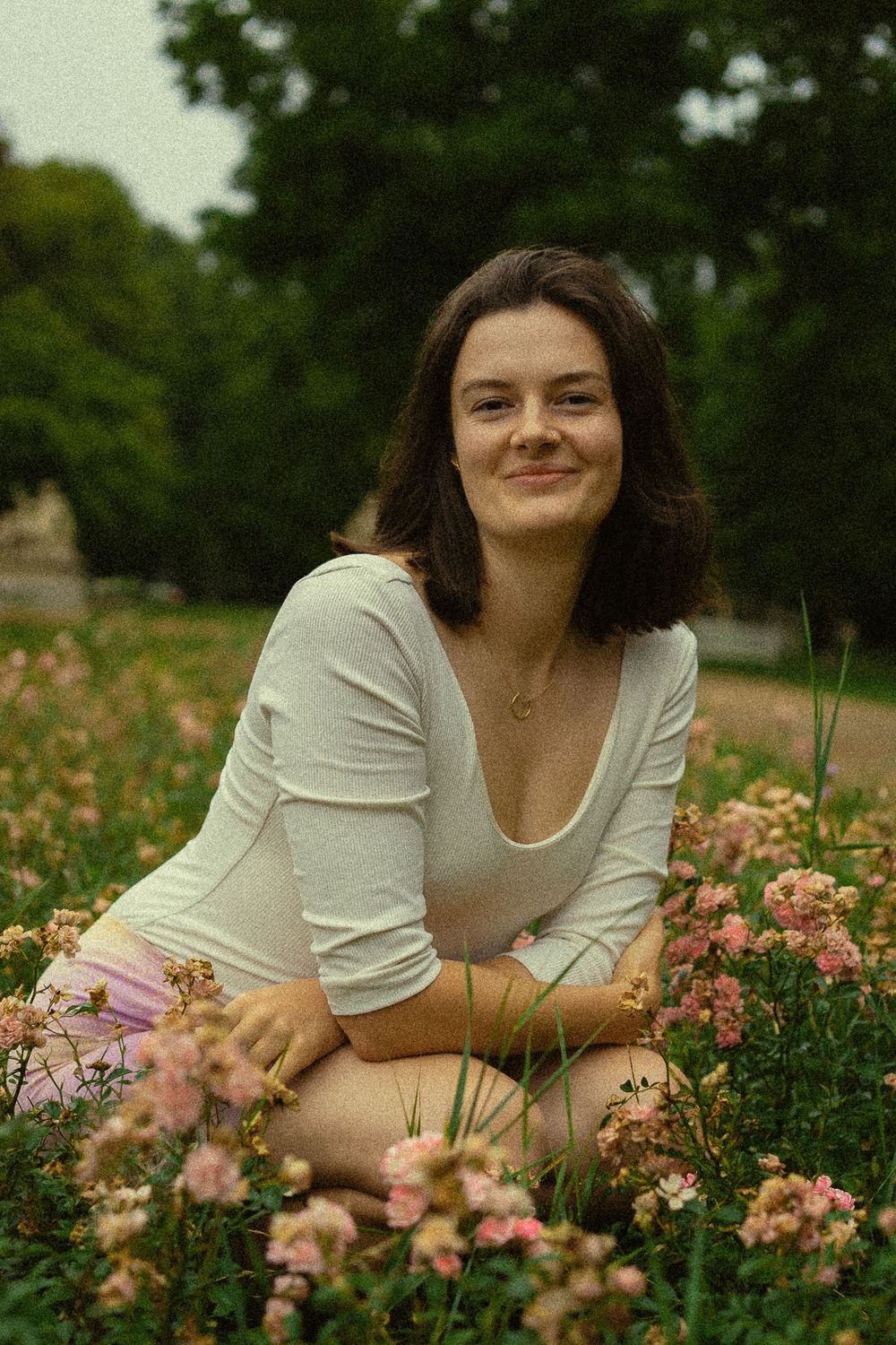 Spätsommerliches Portrait einer hockenden Frau im Blumenfeld im Blüherpark Dresden