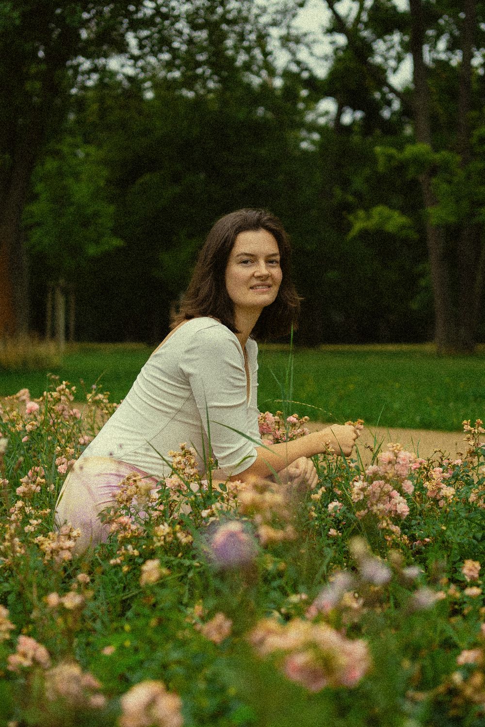 Spätsommerliches Portrait einer hockenden Frau im Blumenfeld im Blüherpark Dresden
