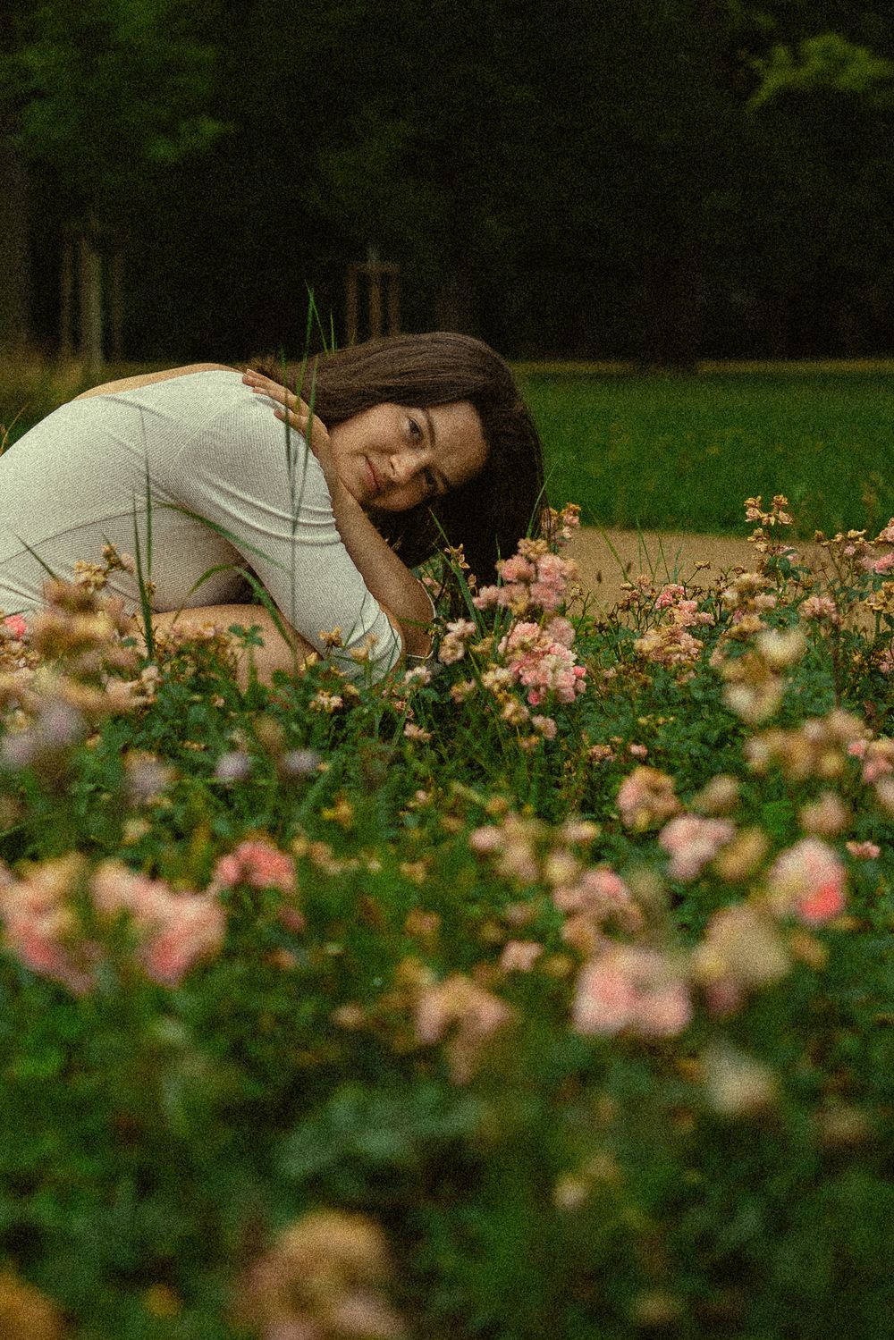 Spätsommerliches Portrait einer hockenden Frau im Blumenfeld im Blüherpark Dresden