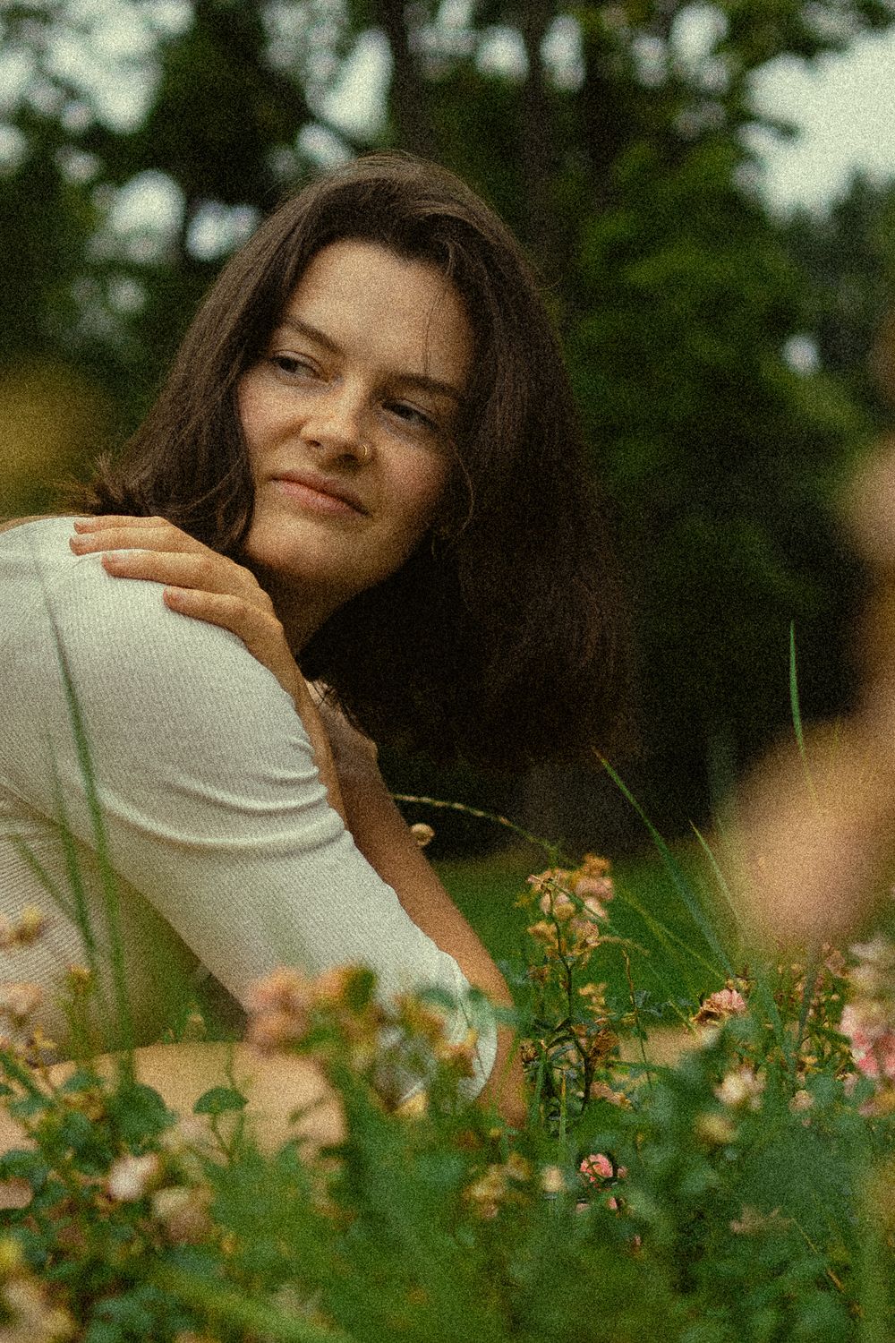 Spätsommerliches Portrait einer hockenden Frau im Blumenfeld im Blüherpark Dresden