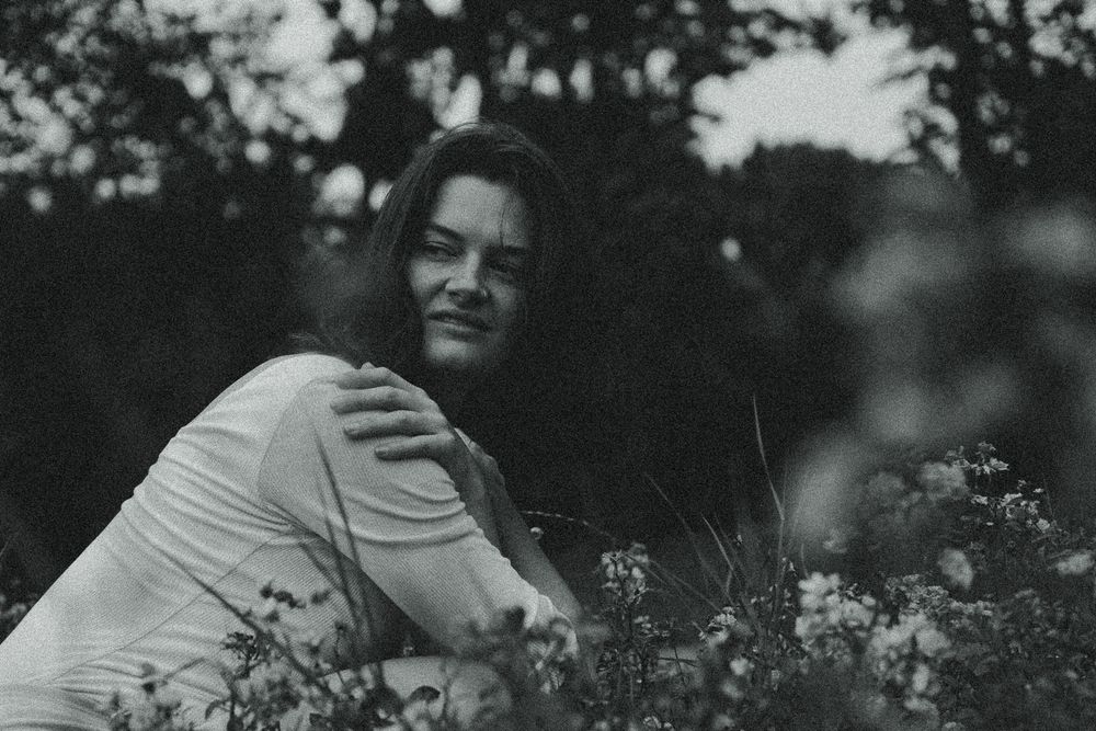 Spätsommerliches Portrait einer hockenden Frau im Blumenfeld im Blüherpark Dresden