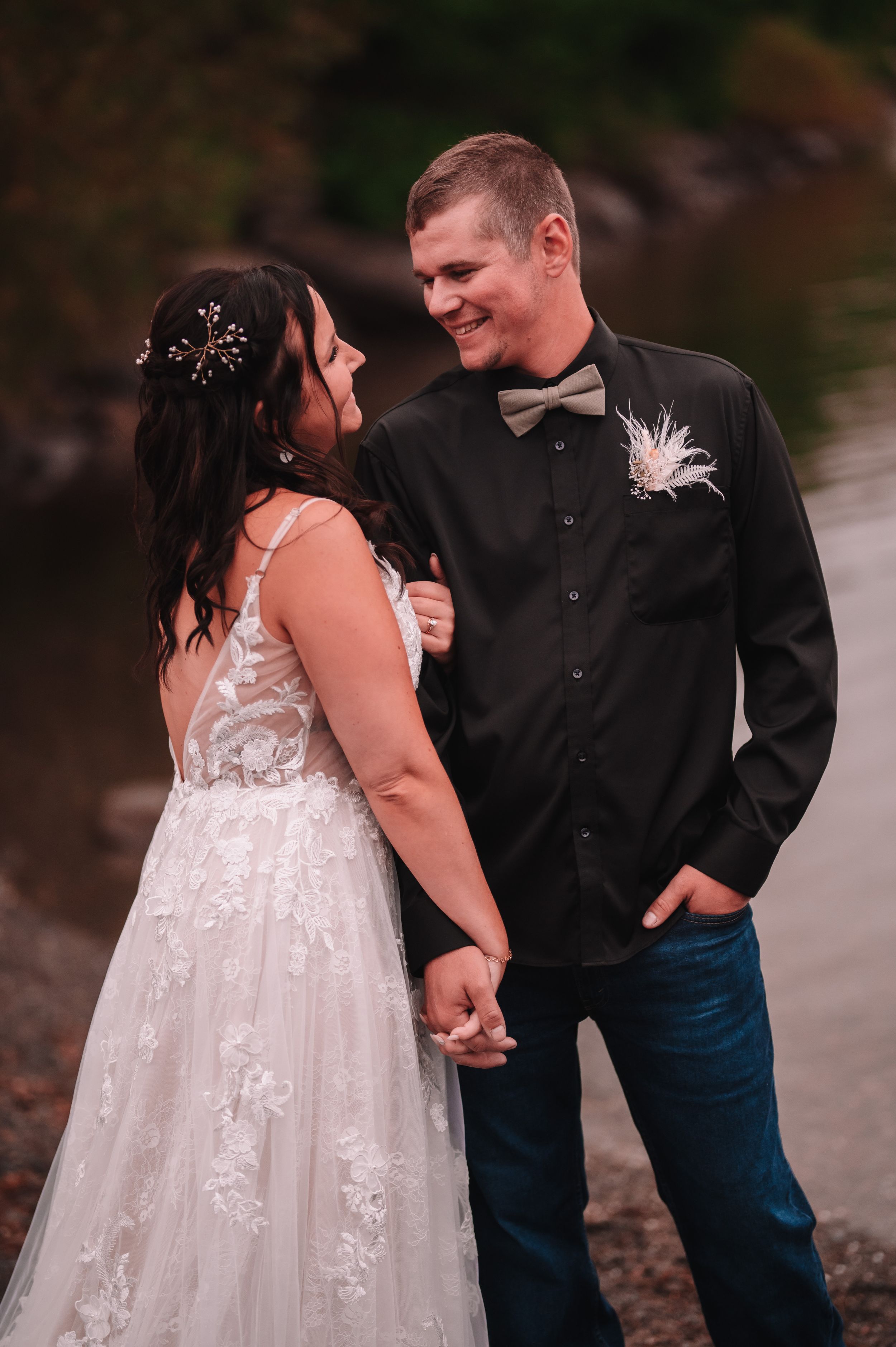 Happy couple share a joyful moment together during their rustic outdoor wedding.